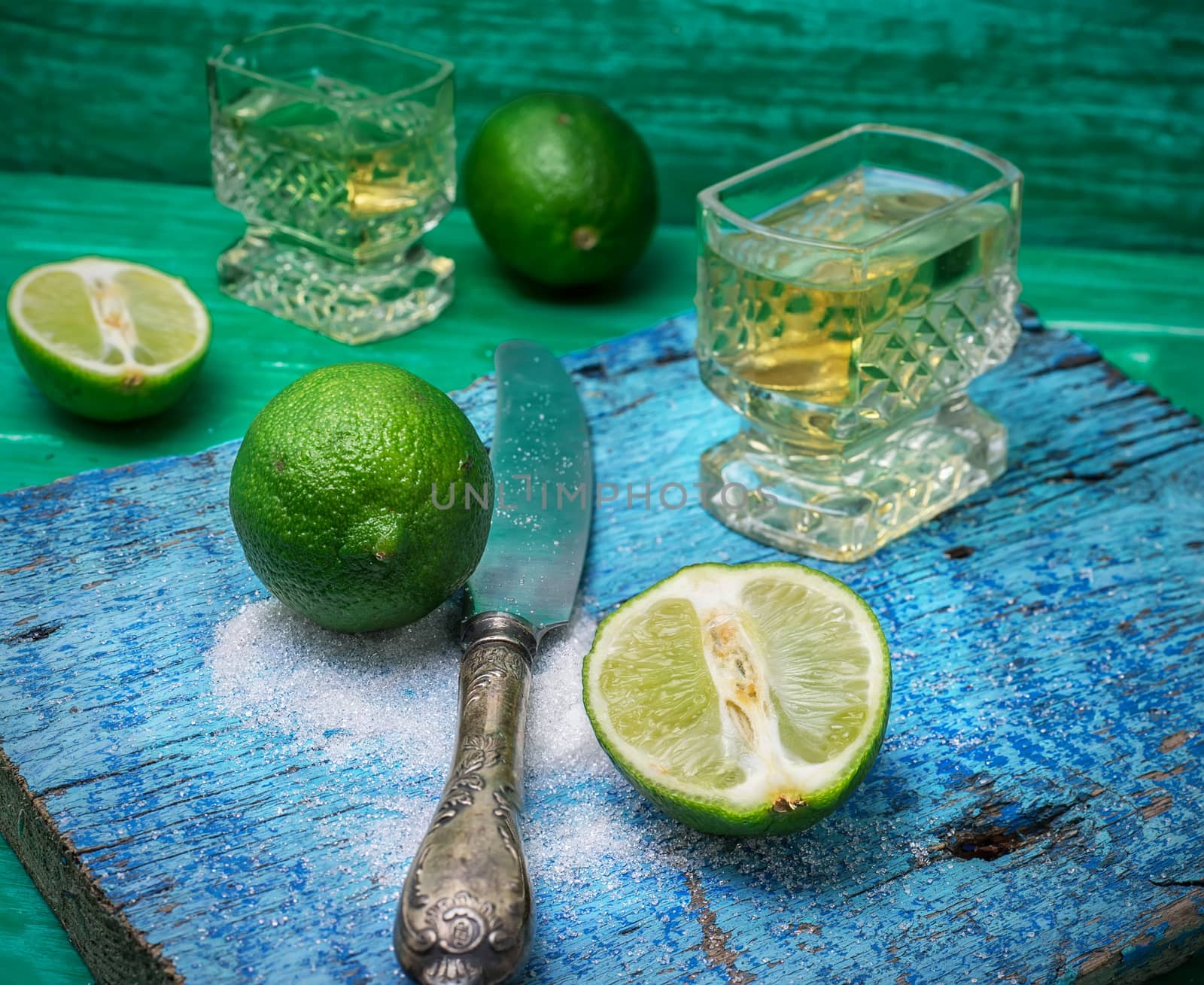 glass alcoholic drink and lime fruits on wooden texture.Selective focus