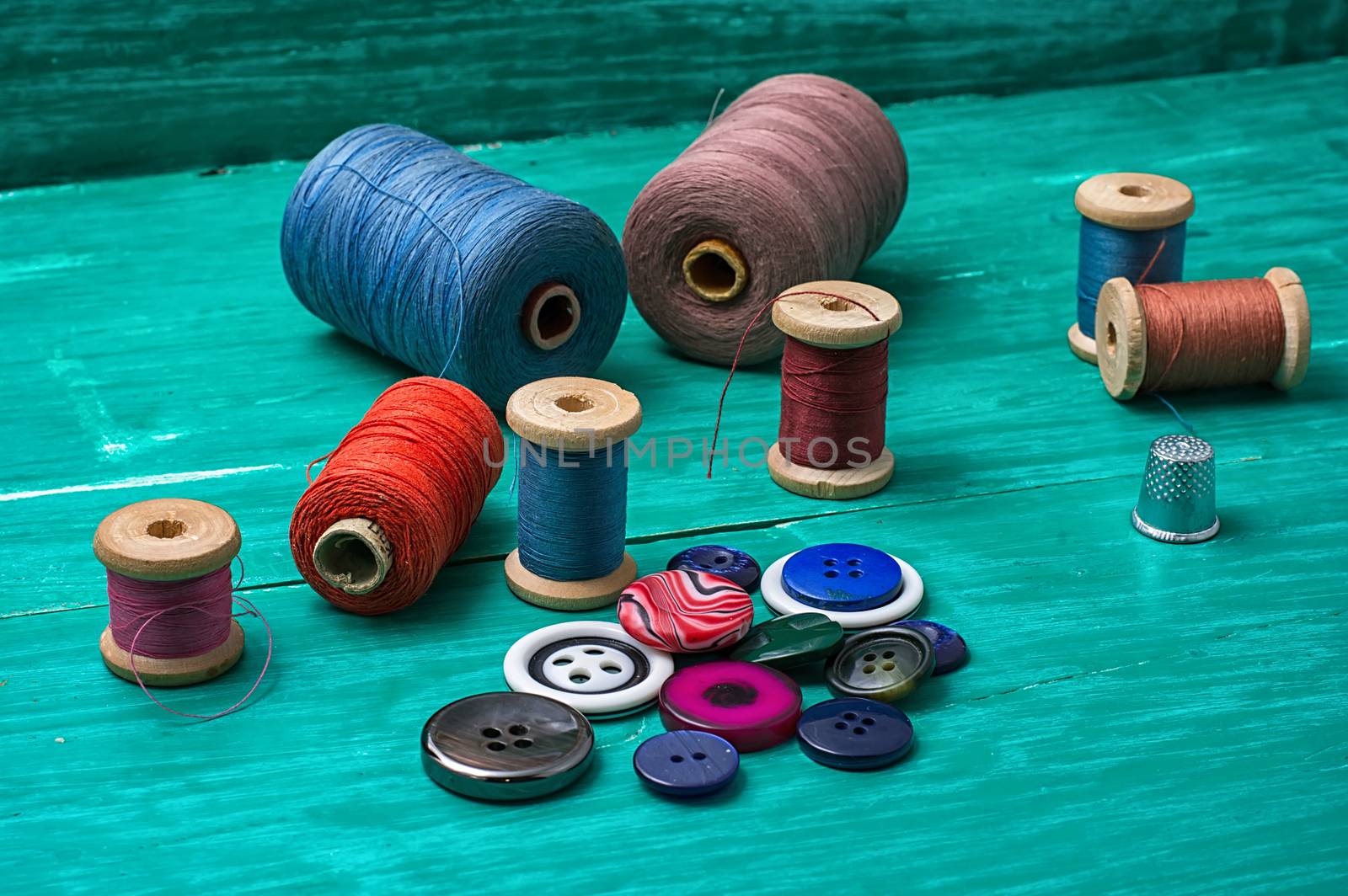 thread buttons for crafts on turquoise wooden background.Selective focus