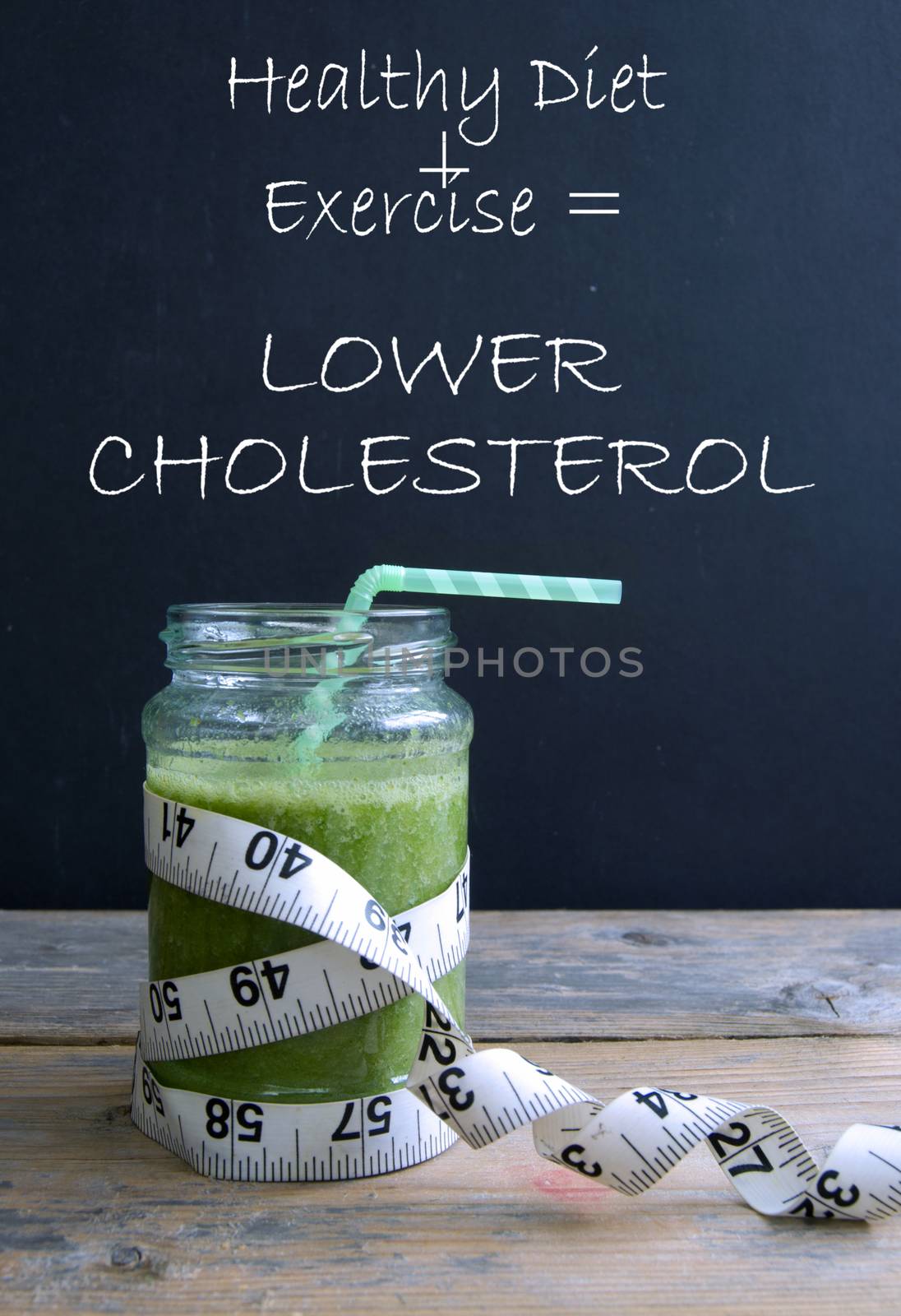 Healthy green smoothie with simple formula for lowering cholesterol written on a chalkboard 