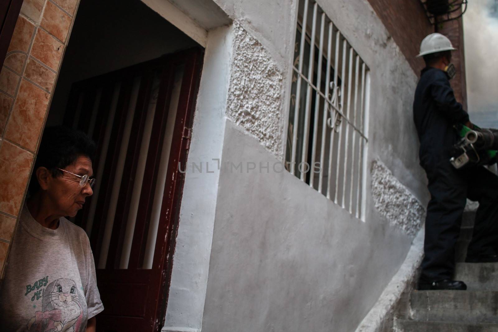 VENEZUELA, Caracas: A resident watches as a member of a fumigation crew exterminates mosquitoes carrying the Zika virus in the slums of Caracas, Venezuela on February 3, 2016. As of February 4, there have been reports of at least 255 cases of the rare Guillain-Barre syndrome  which causes the immune system to attack the nerves  potentially linked to the Zika virus in Venezuela.