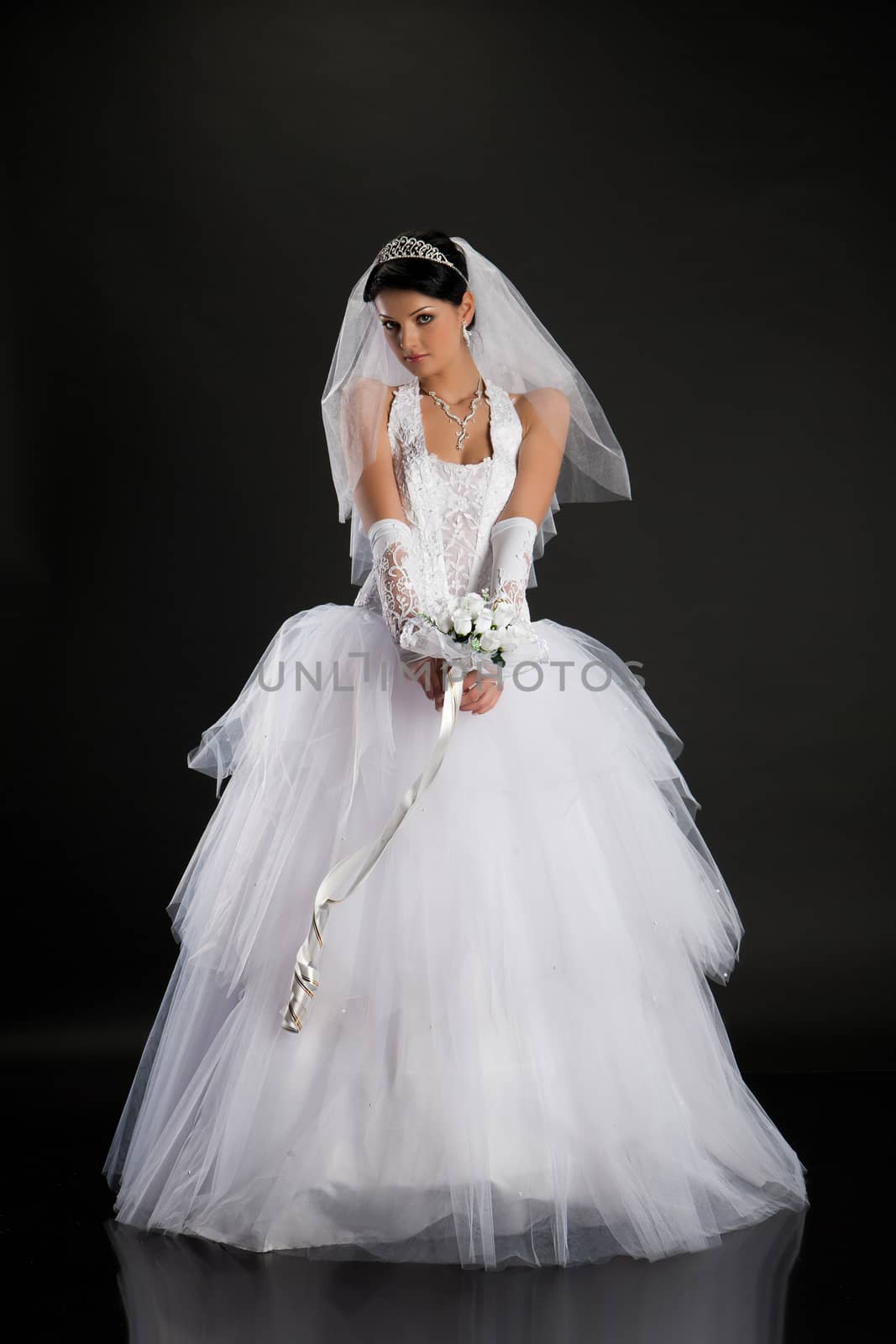 Young beautiful woman in a wedding dress on a studio background