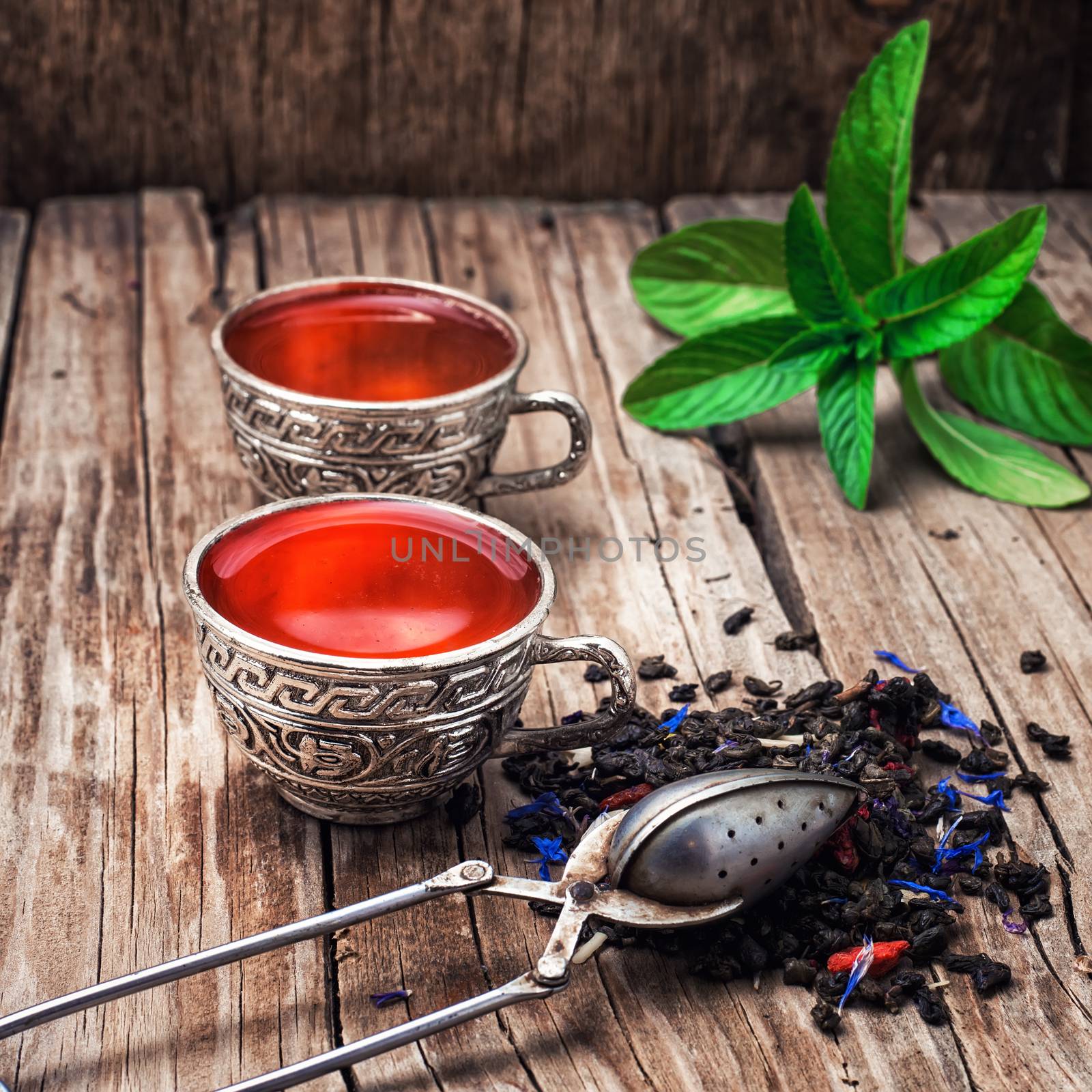 two iron bowls with herbal tea on background of mint leaves.Selective focus