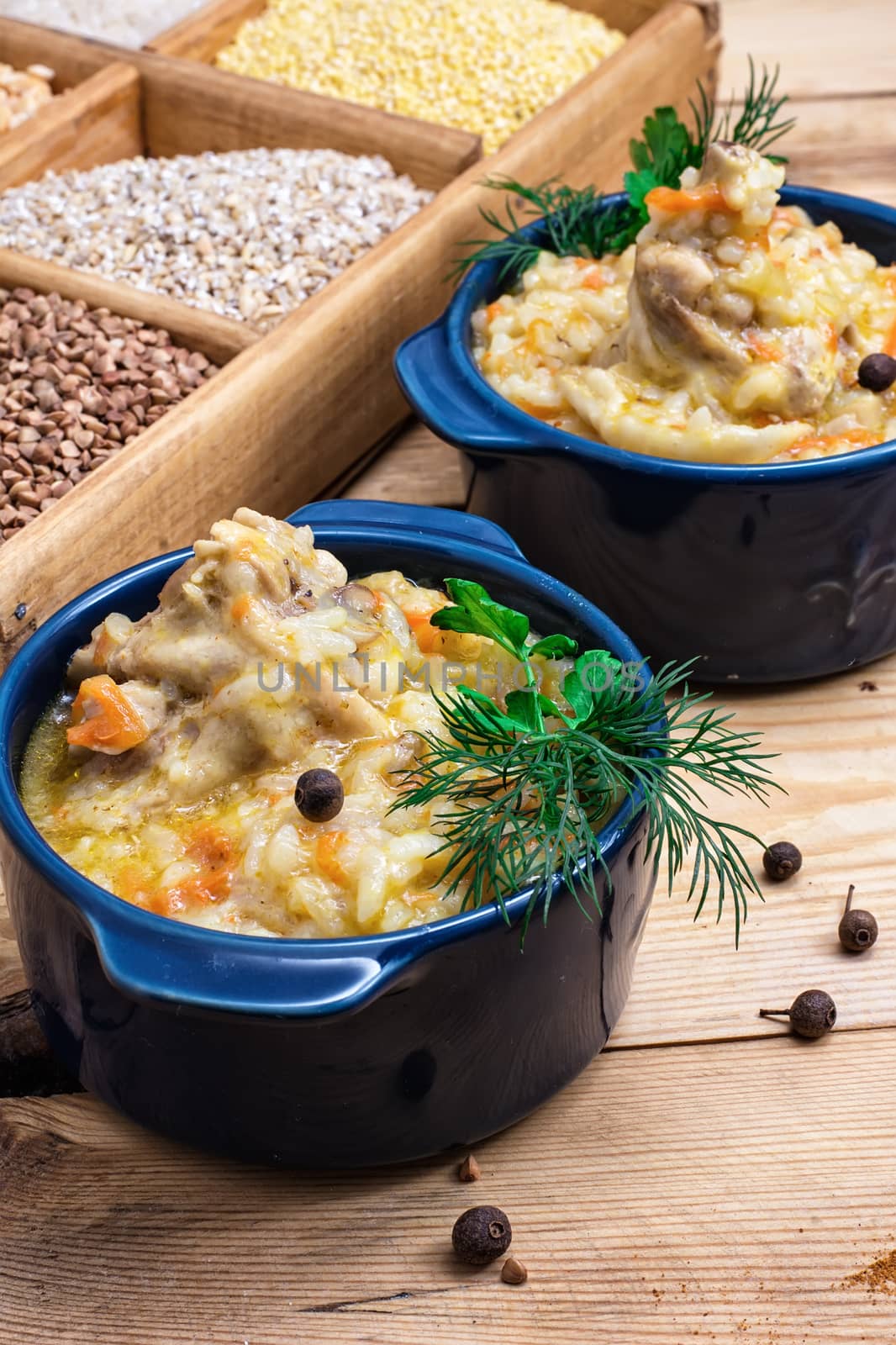 wooden box with varieties of cereals on the background of the cooked pilaf.Selective focus