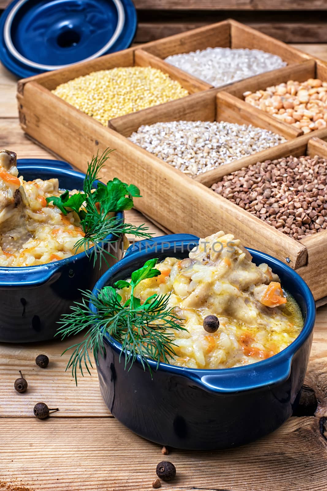 wooden box with varieties of cereals on the background of the cooked pilaf.