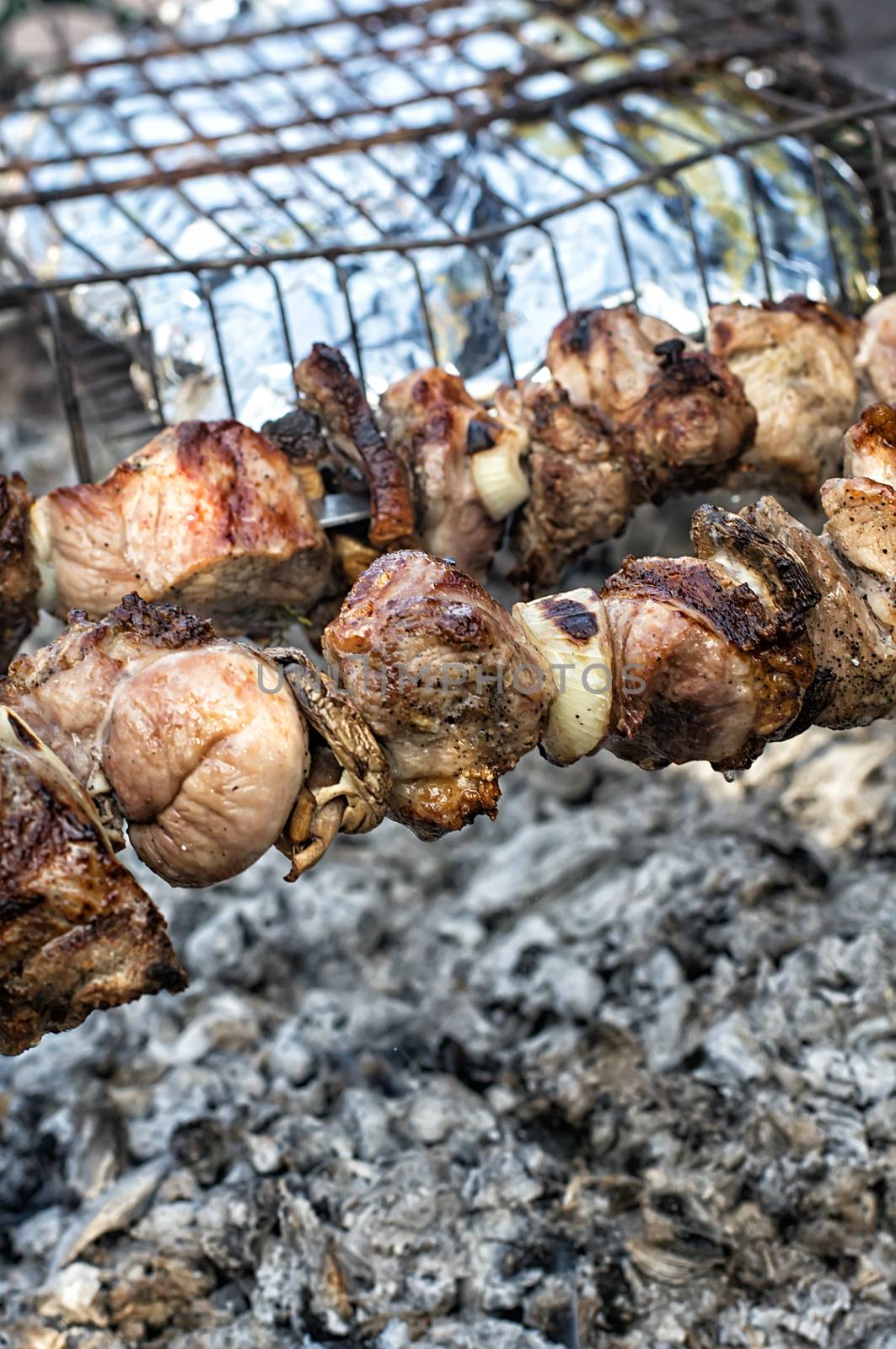 grilling pork on skewers over charcoal in the grill.Selective focus