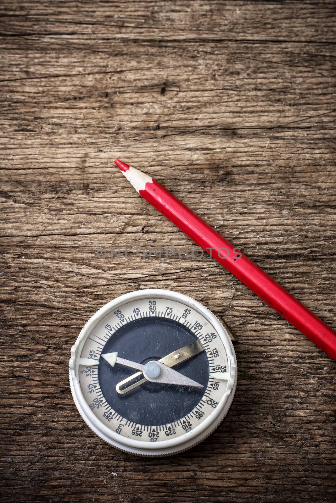 obsolete compass on wooden table top in retro style