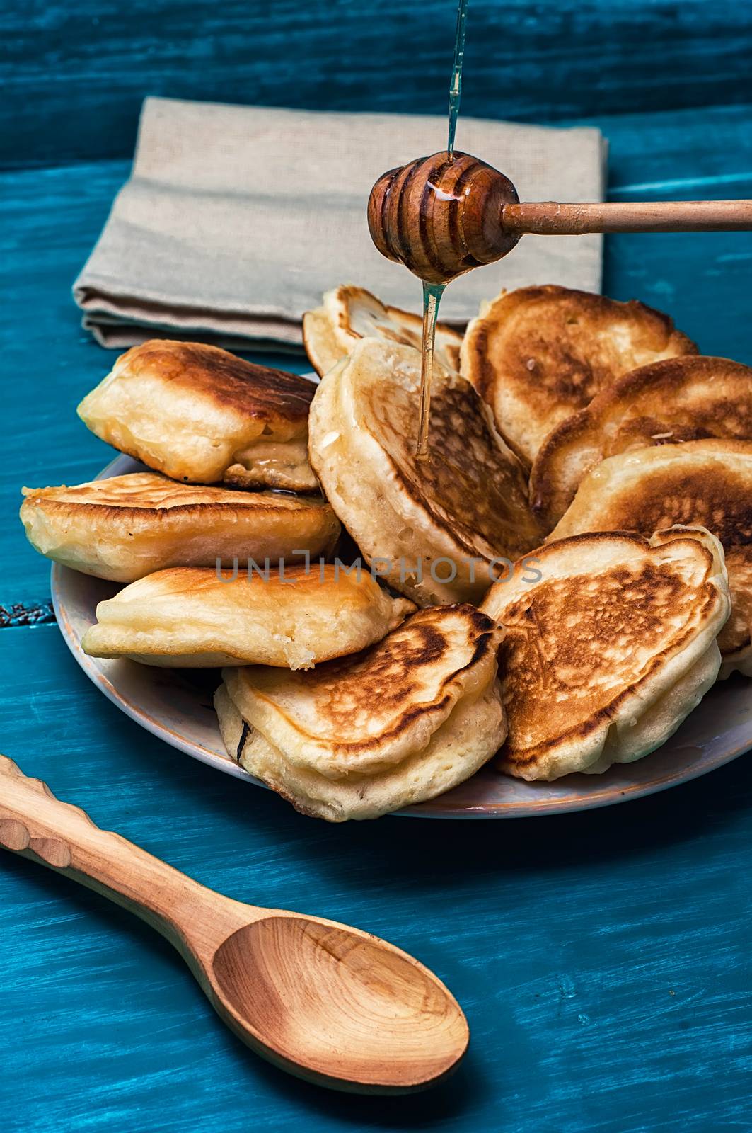 pancakes drizzled with jam on blue wooden board.