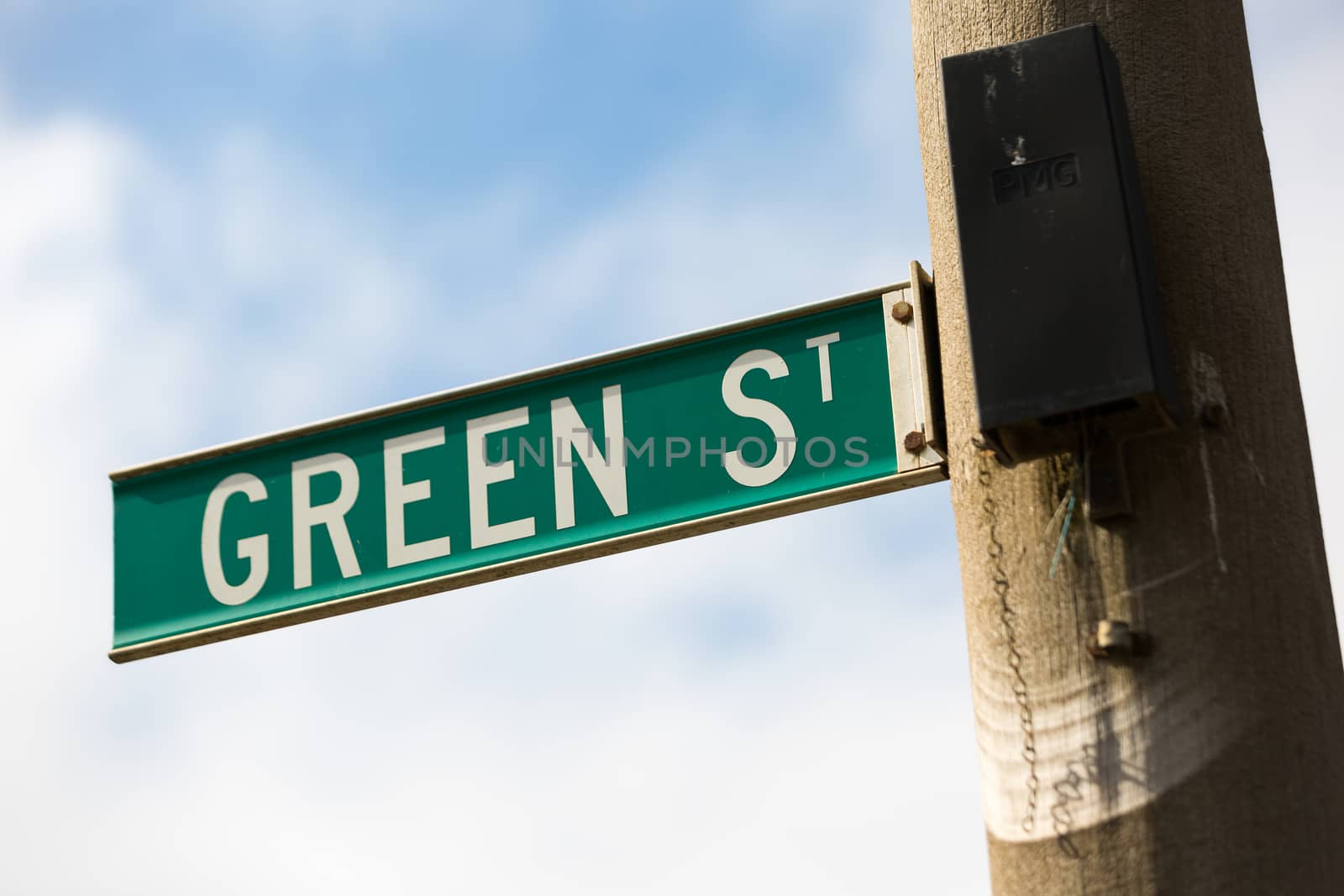 A green street sign with white lettering with the words - 'Green St'