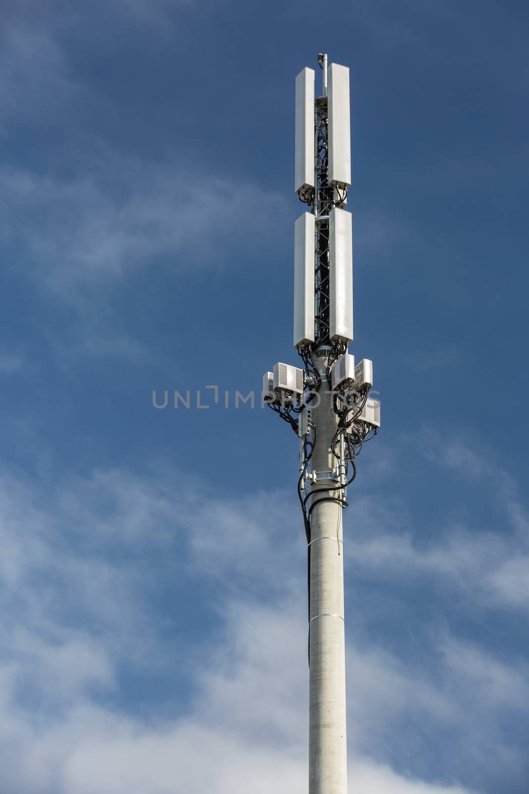 Cell phone tower against a partly cloudy sky.