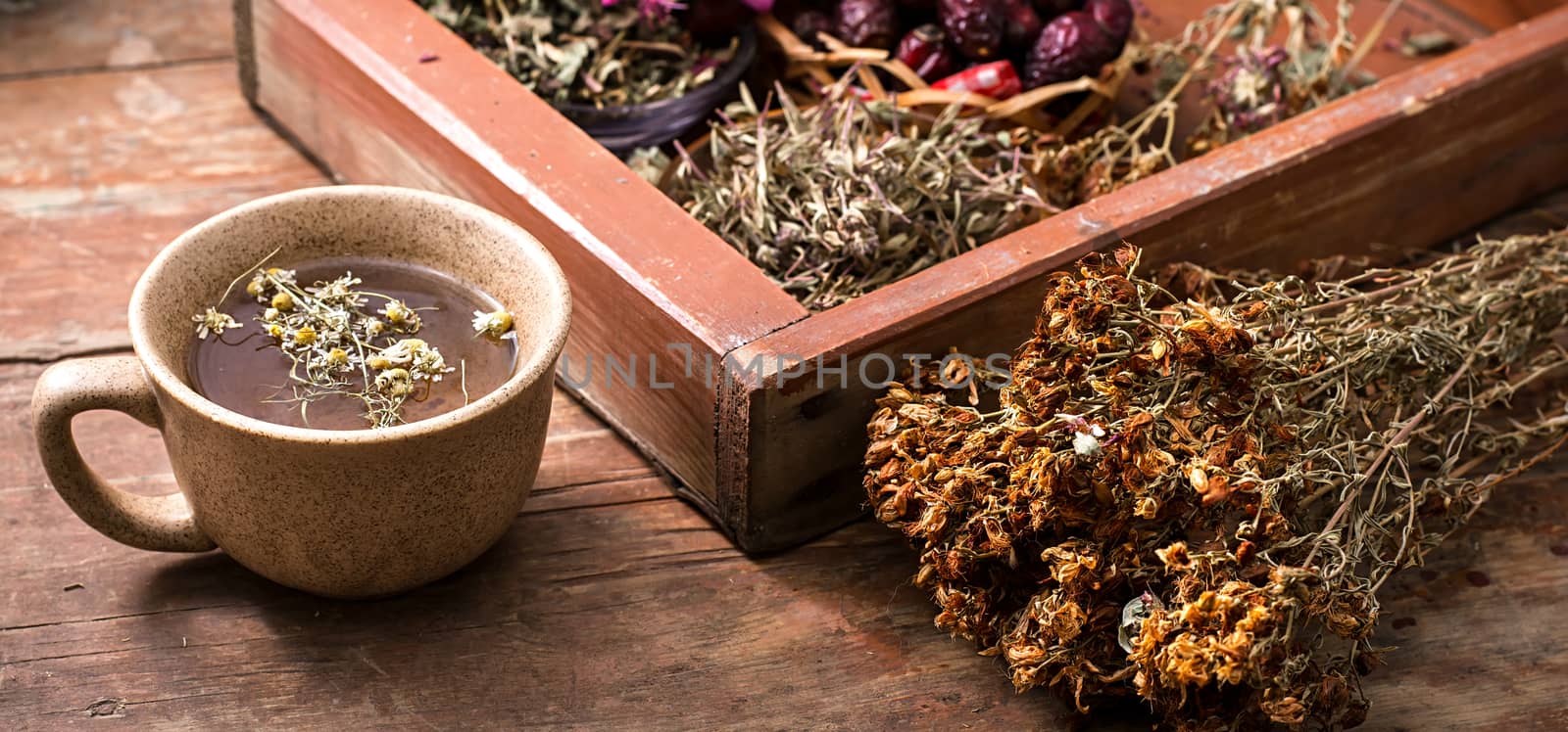 ceramic cup with tea brewed from dried chamomile and medicinal herbs.Selective focus