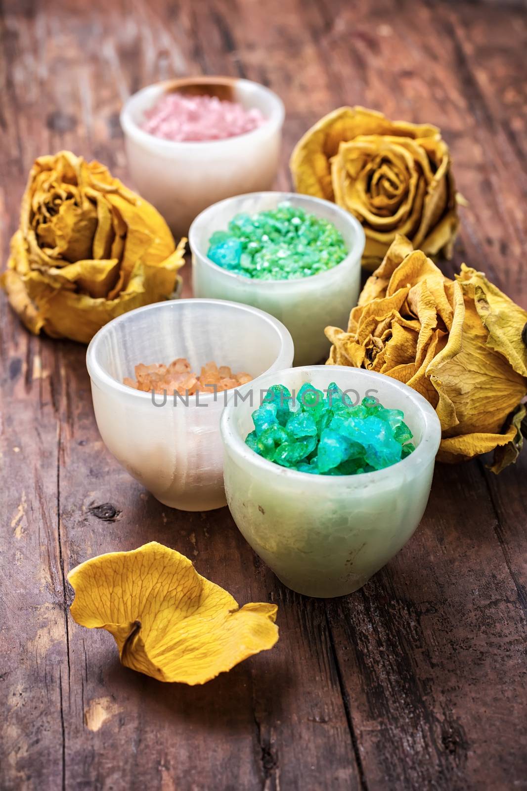 sea salt for Spa treatments with ceramic cups on the background of the buds dried yellow roses