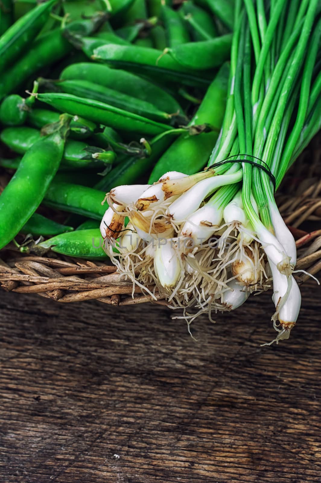 leek and green peas in basket in rustic style.The image is tinted