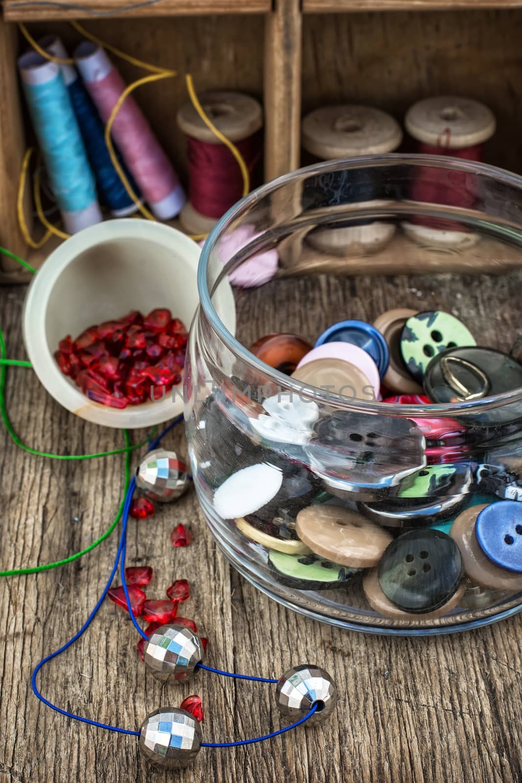 vase with buttons and different tools for needlework beading and sewing .Selective focus