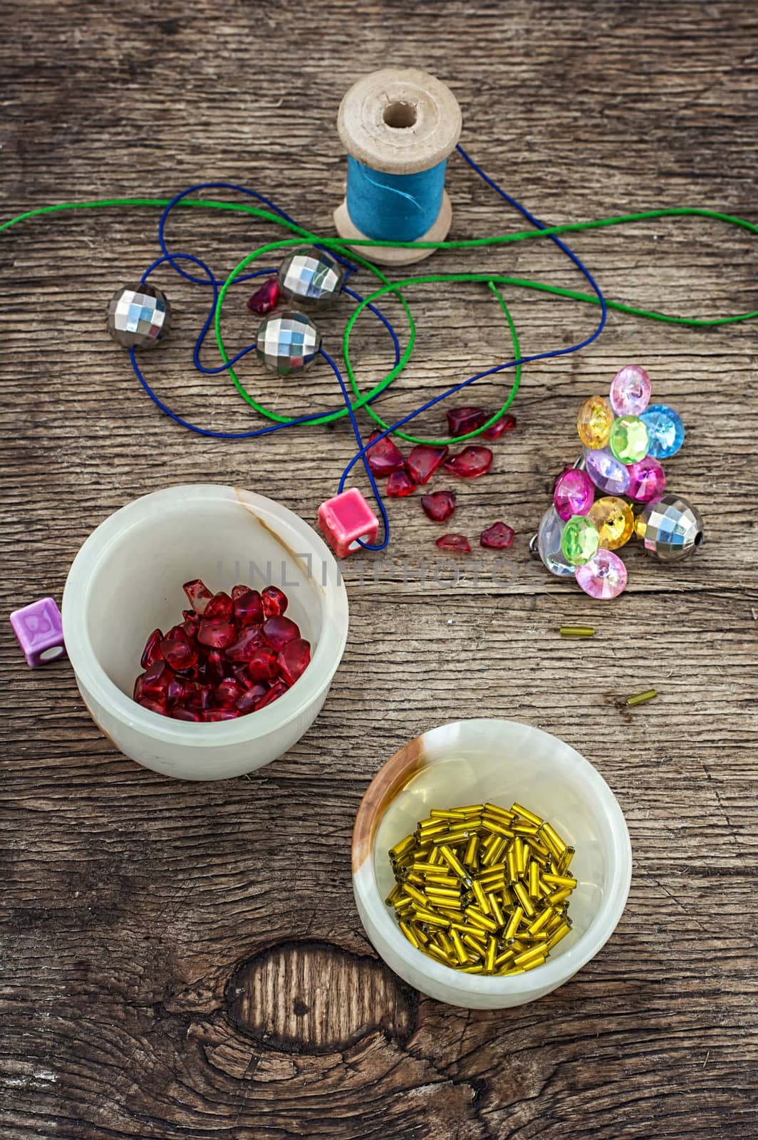 set of beads in stacks on wooden table with tools for needlework.Selective focus.Photo tinted