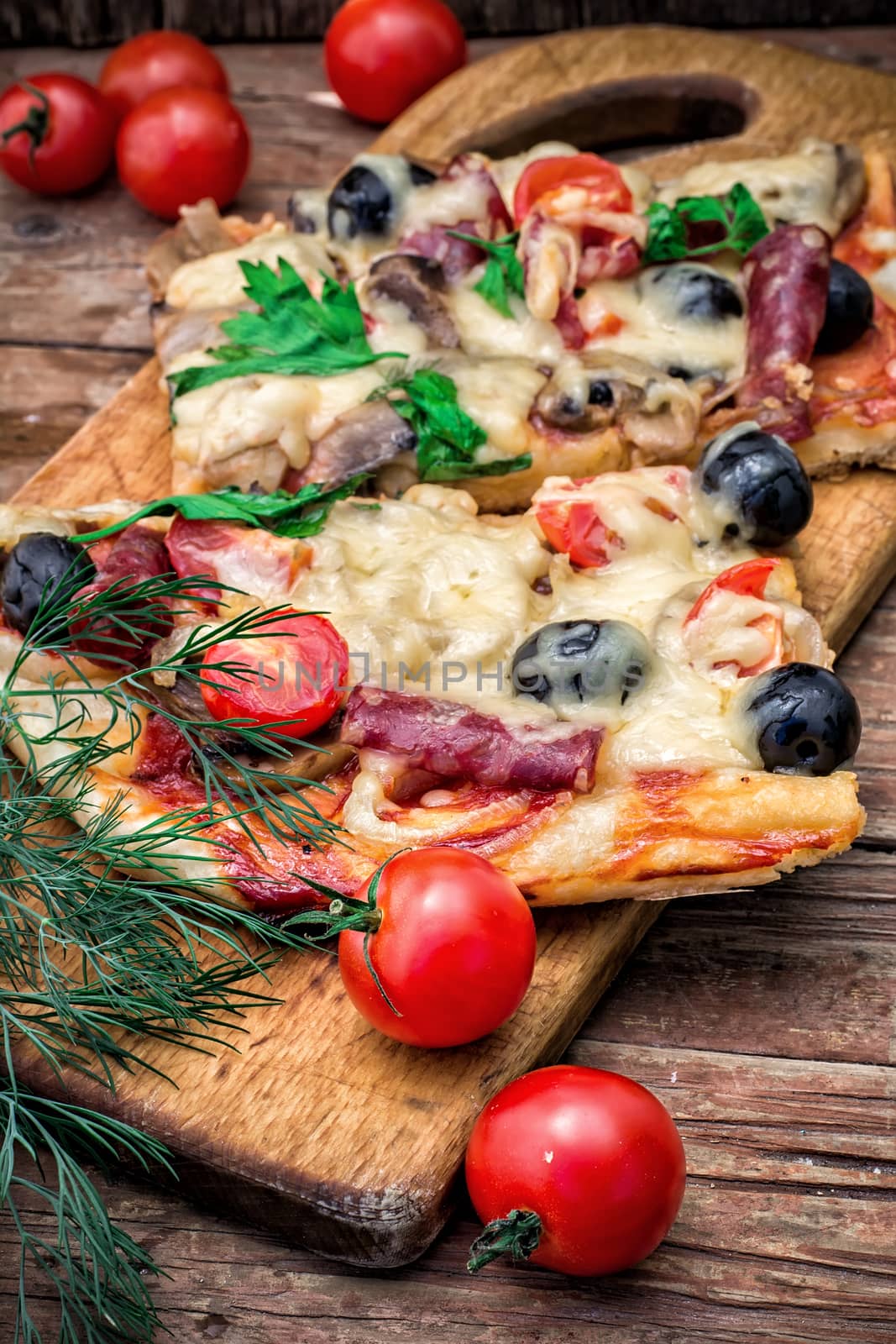 meat pizza made with salami,cheese,mushrooms,cherry tomatoes and olives.The image is tinted.