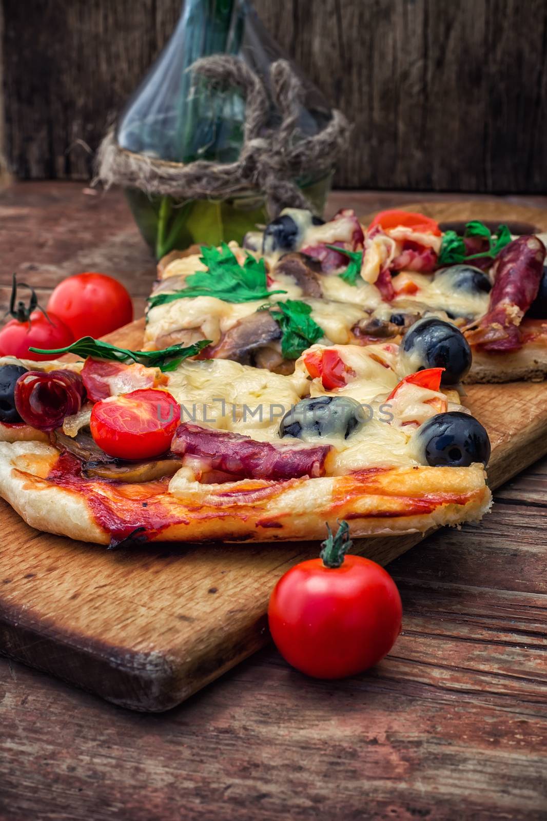meat pizza made with salami,cheese,mushrooms,cherry tomatoes and olives.The image is tinted.