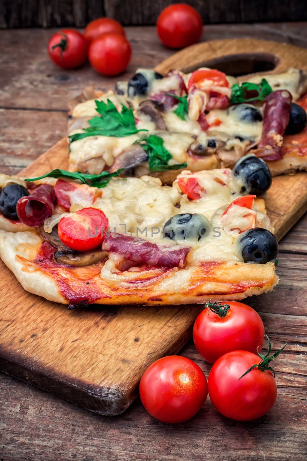 meat pizza made with salami,cheese,mushrooms,cherry tomatoes and olives.The image is tinted.