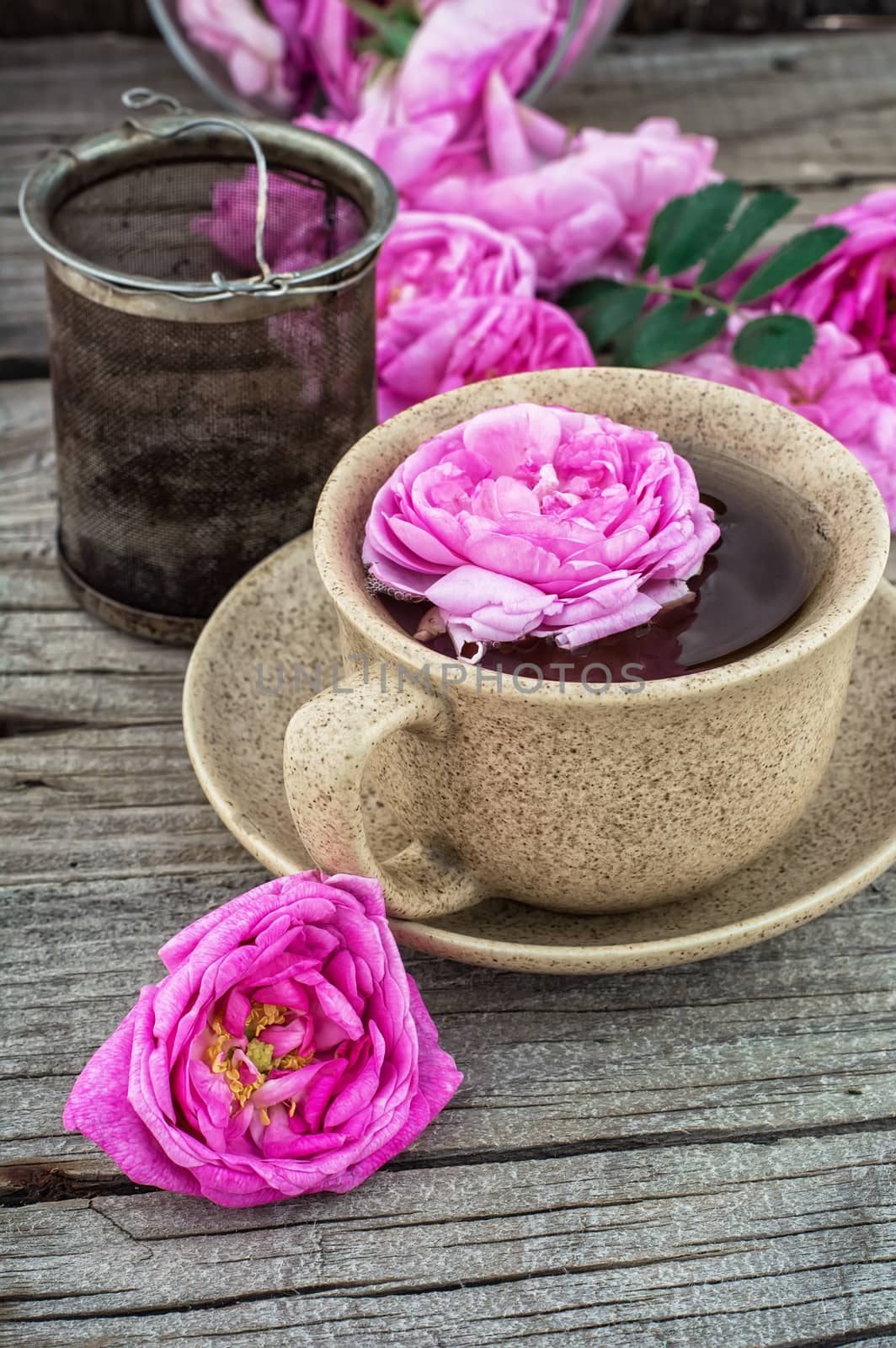 Cup with fresh fragrant herbal decoction of tea rose.The image is tinted