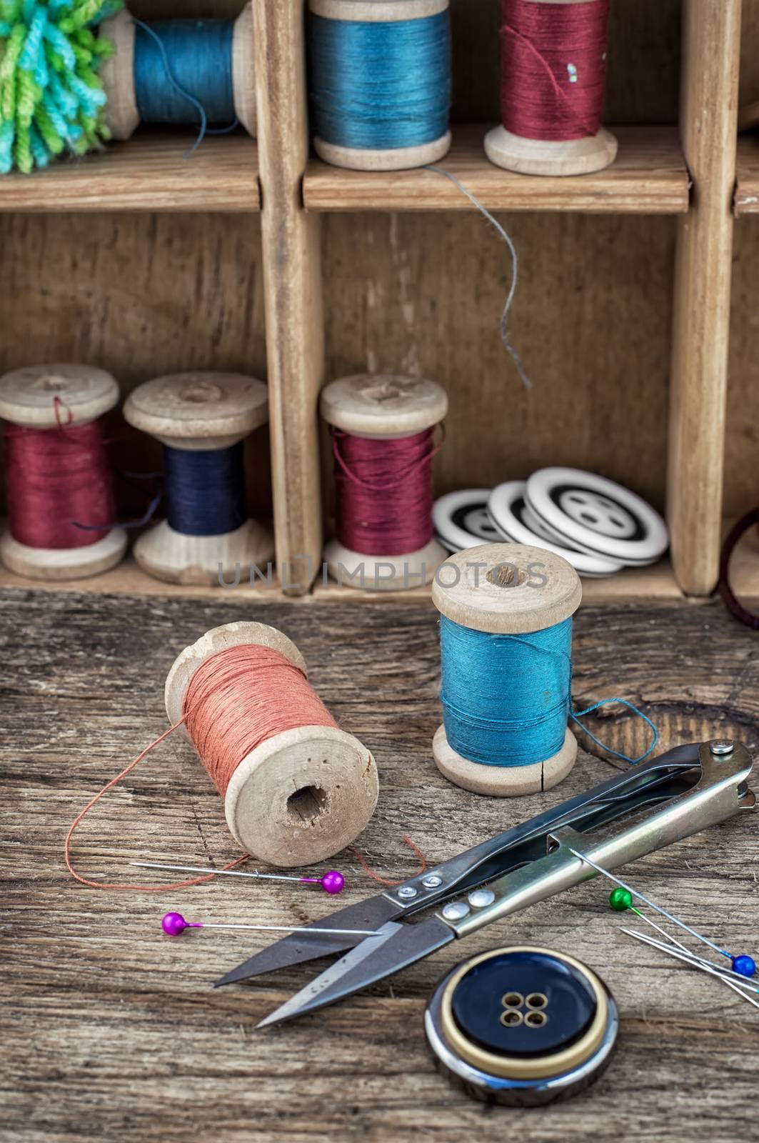 set of threads and buttons on wooden background.Selective focus