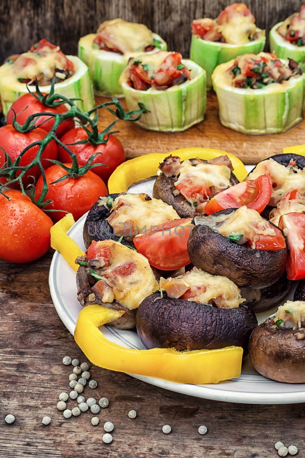 Easy appetizer of mushrooms stuffed with cheese,garlic and tomatoes.Rustic kitchen.Photo tinted.Selective focus