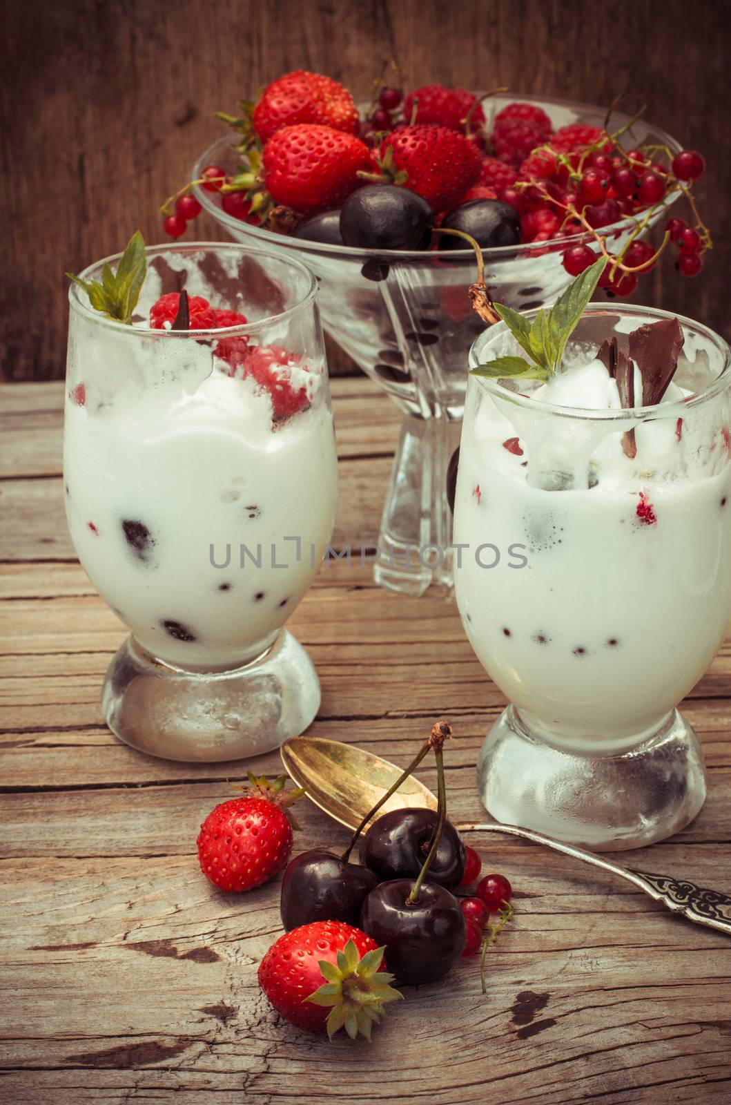 sweet dessert of ice cream per glass and fresh berries, cherries,currants,strawberries.Photo tinted.