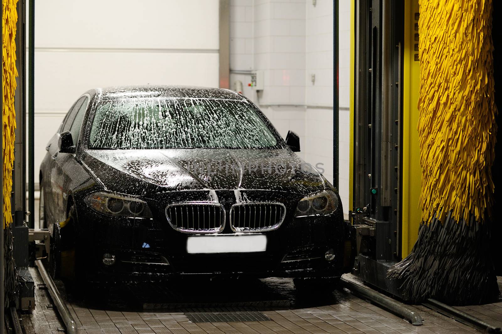 Black car washing in station washing tunnel
