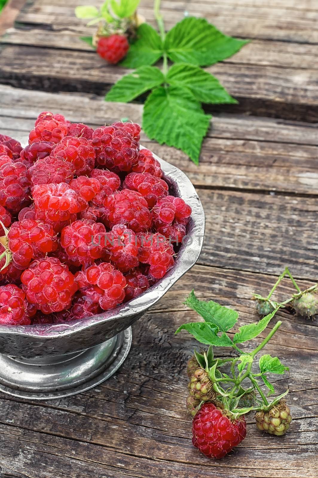 Plucked raspberries in vintage iron ramekin.Photo tinted.