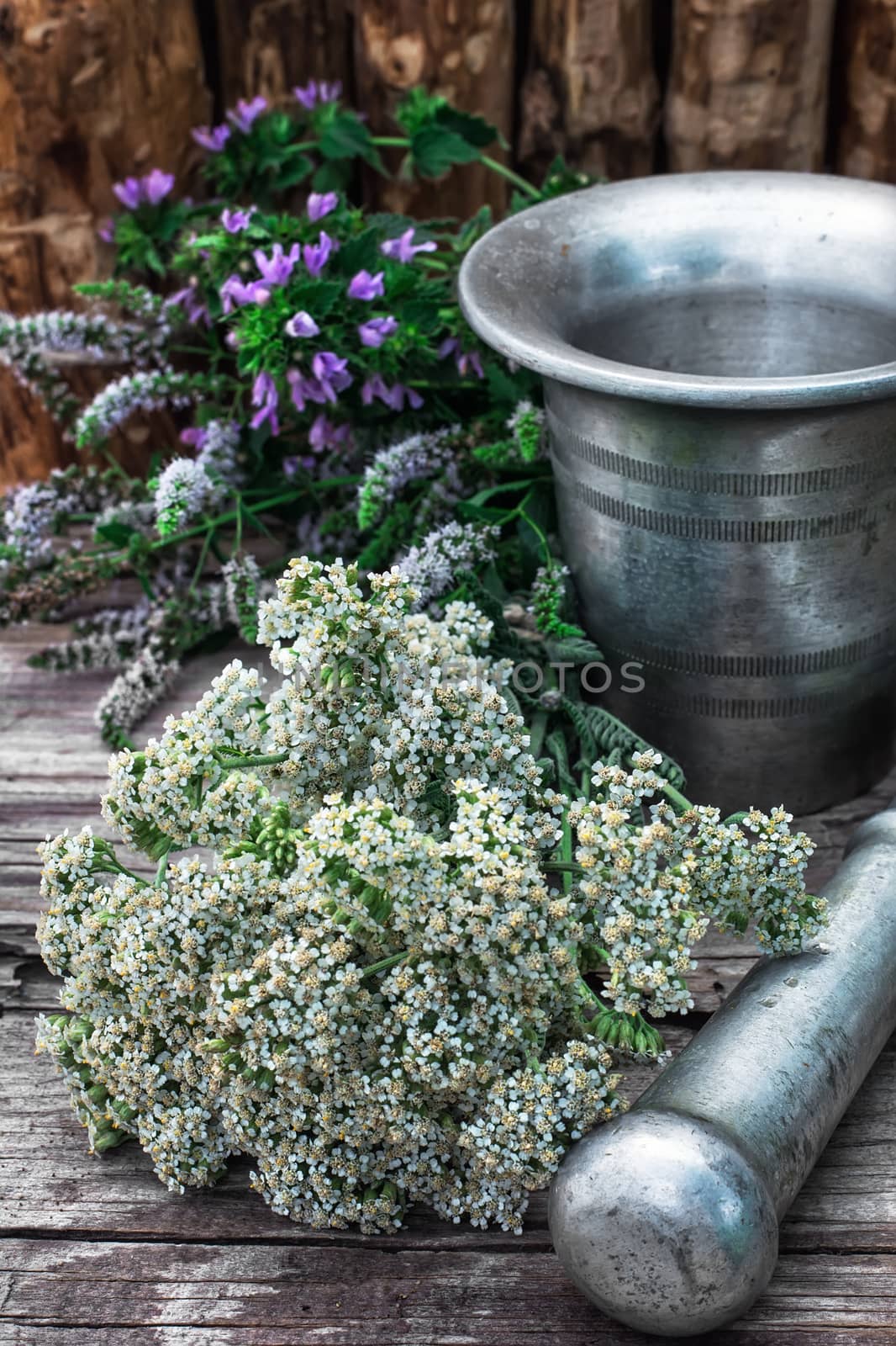 Cut bunch of cherry peppermint and yarrow amid mortar in the rural style.Photo tinted.Selective focus