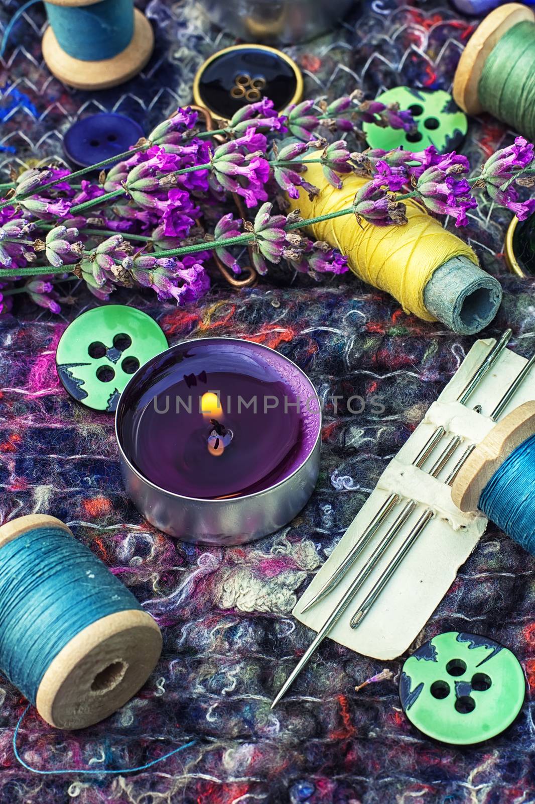 sewing thread and buttons on the background batting is decorated with blooming lavender.Photo tinted.Selective focus
