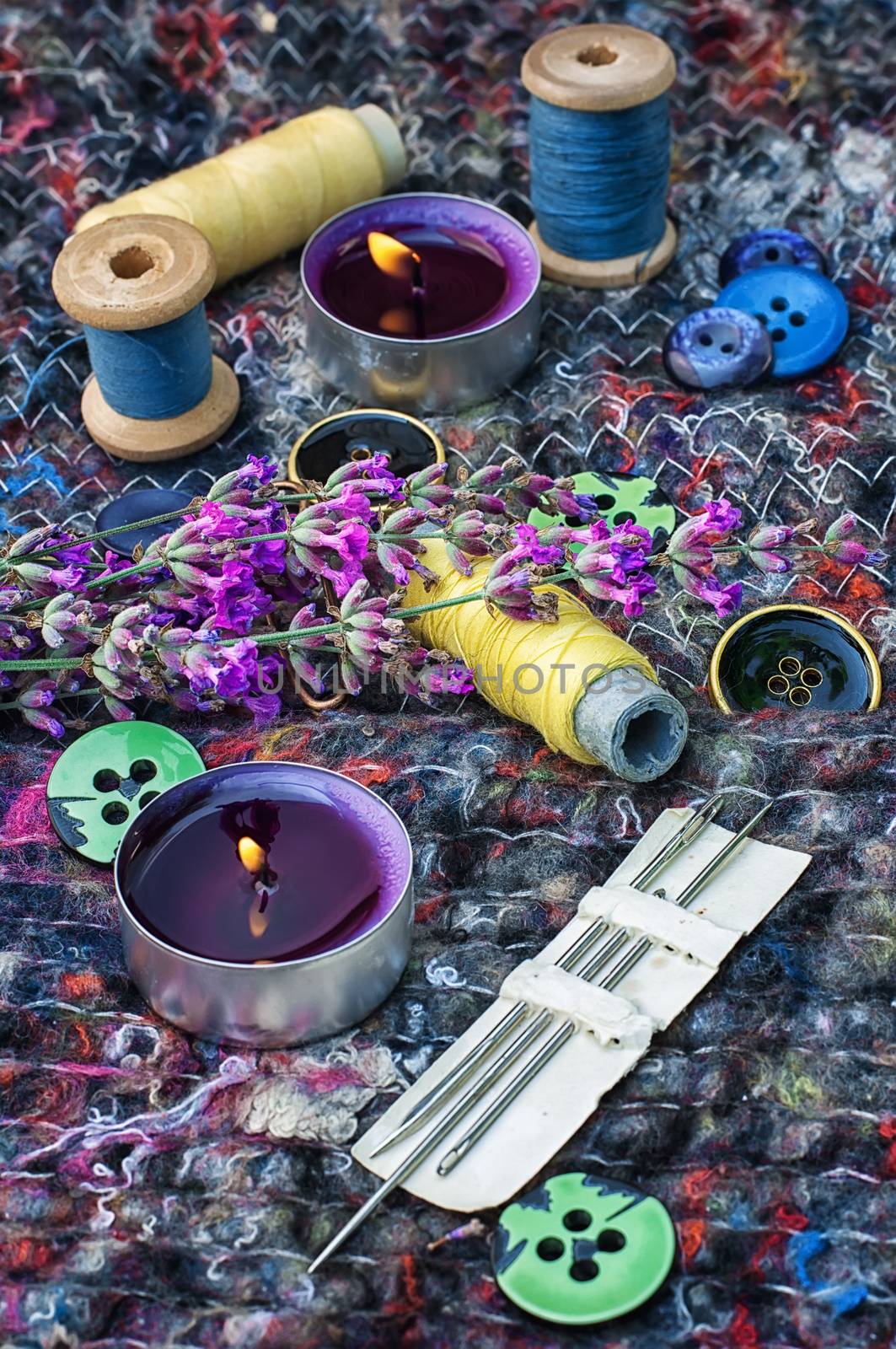sewing thread and buttons on the background batting is decorated with blooming lavender.Photo tinted.Selective focus