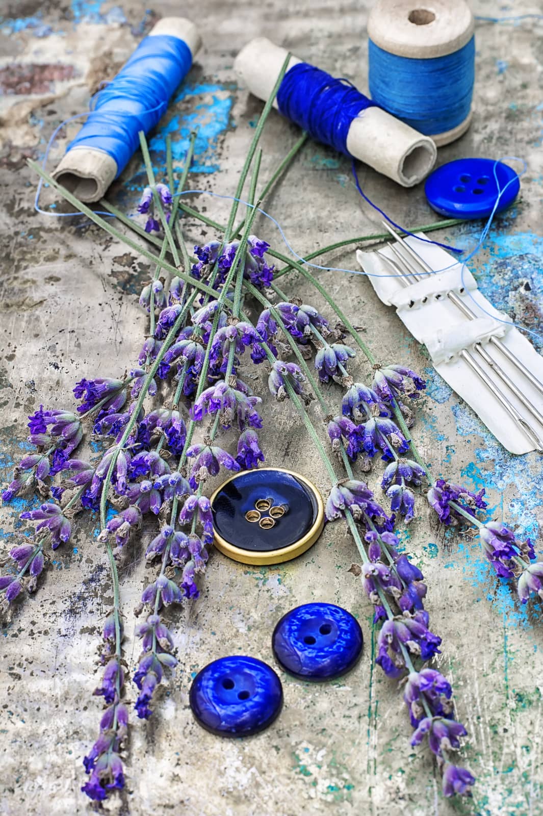 sewing thread and buttons on the background metal is decorated with blooming lavender.Photo tinted.