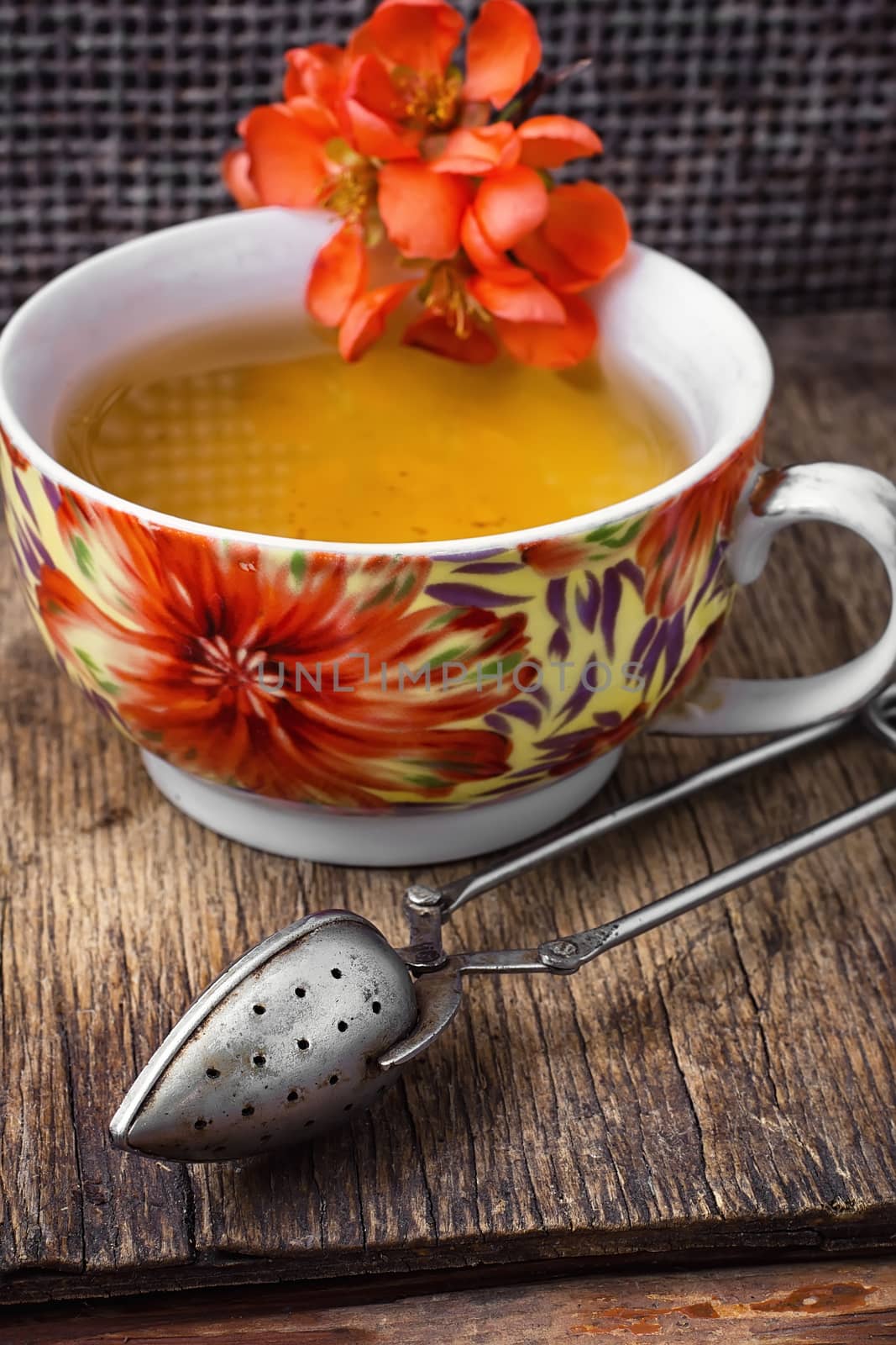 Cup of flower tea, on wooden table in vintage style.Photo tinted.