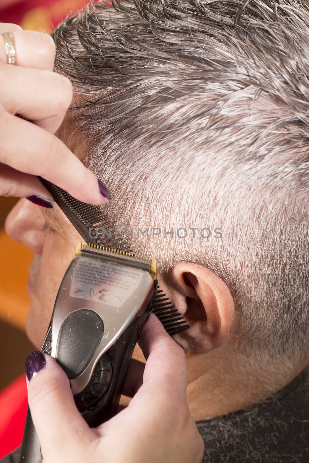 woman cuts hair with scissors, razor in  professional hairdressing salon