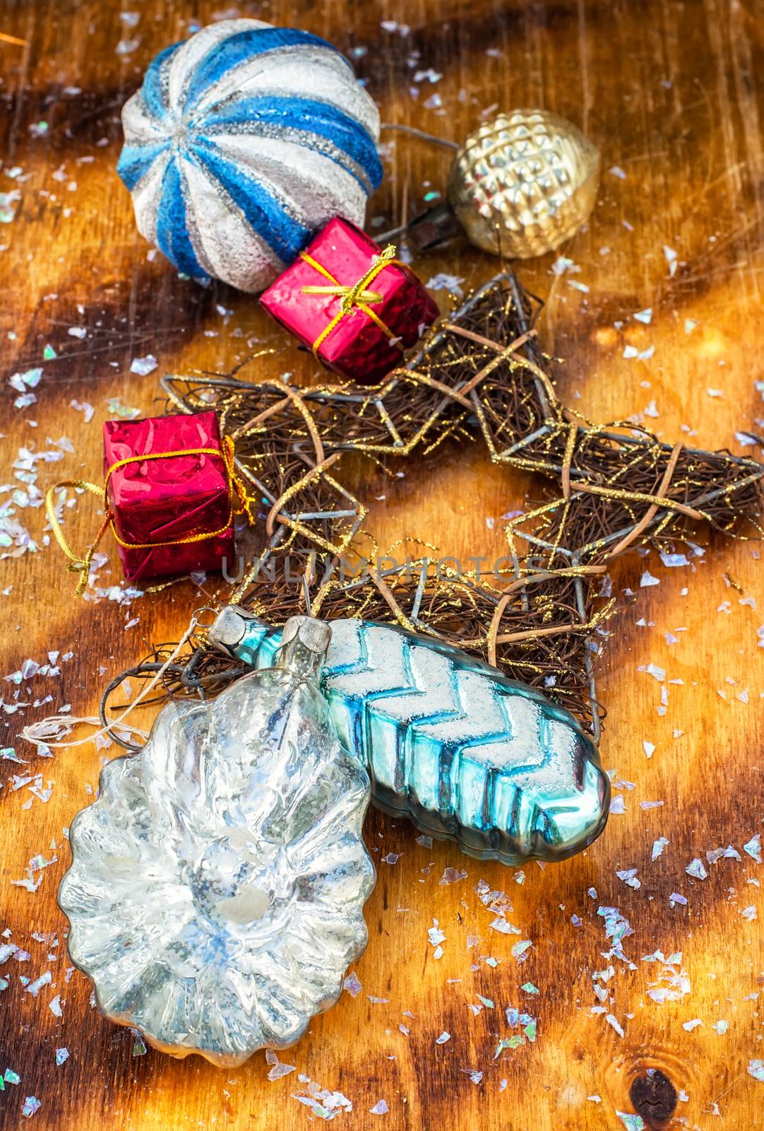 Vintage antique decorations for Christmas trees on bright yellow wooden background.