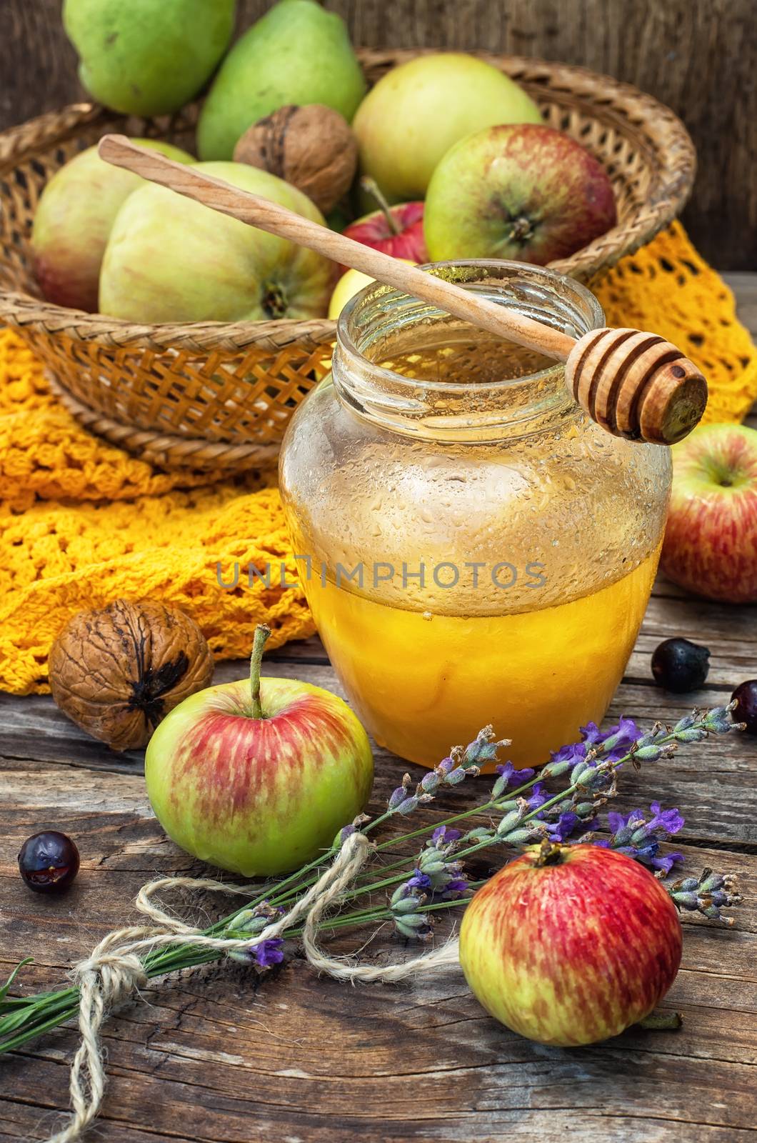 Autumn harvest of apples in the background of the glass jar with fragrant honey.Photo tinted