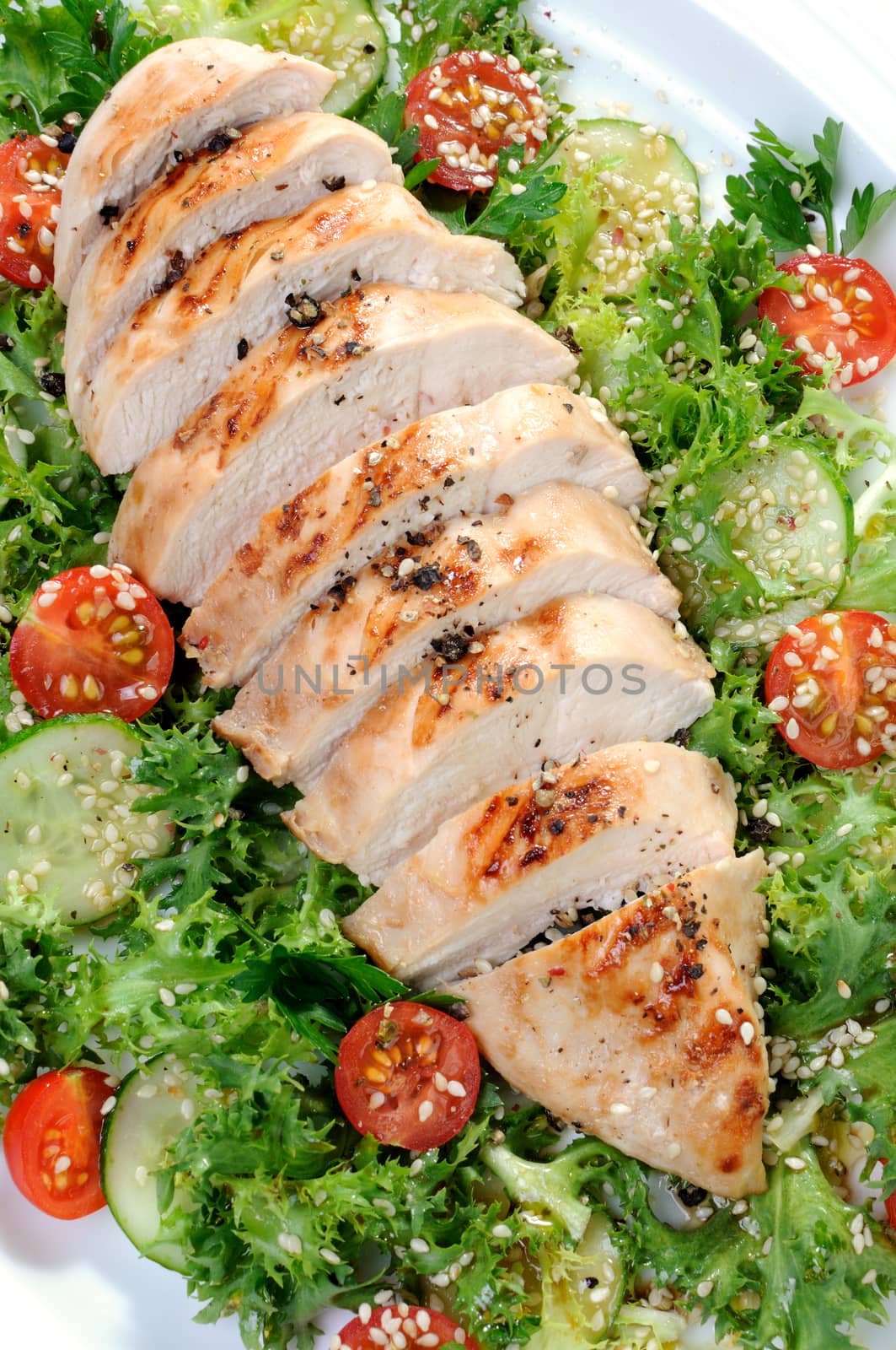 Cut into slices of grilled chicken breast with vegetable garnish