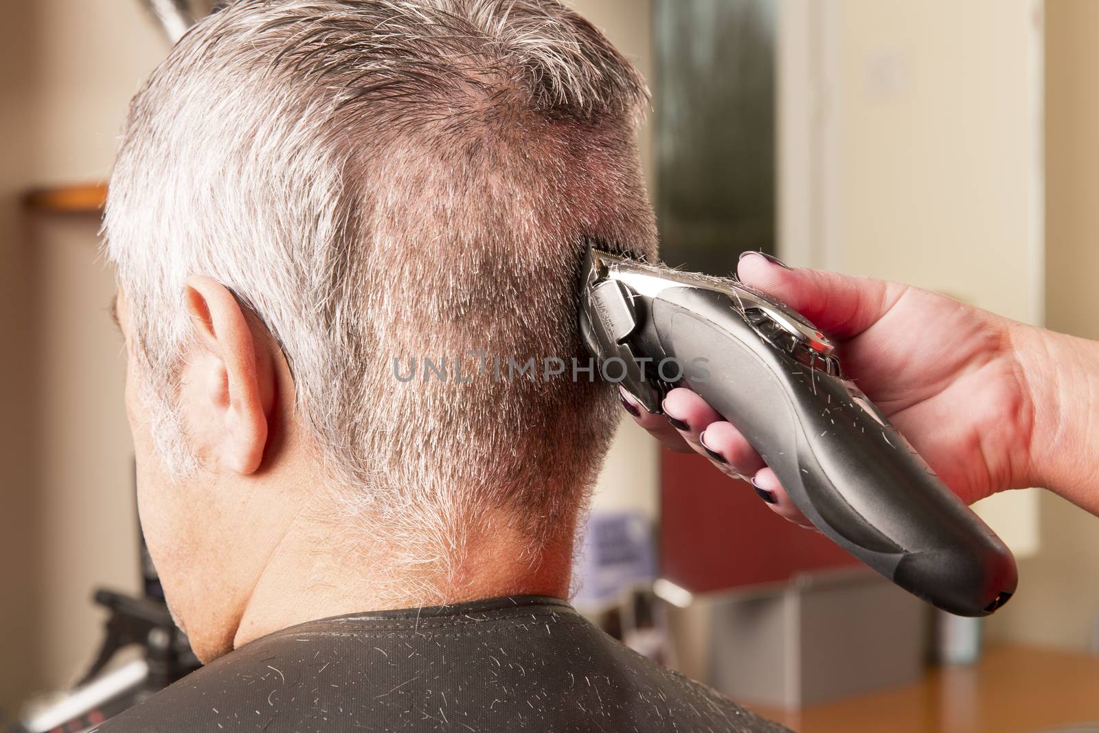 woman cuts hair with scissors, razor in  professional hairdressing salon