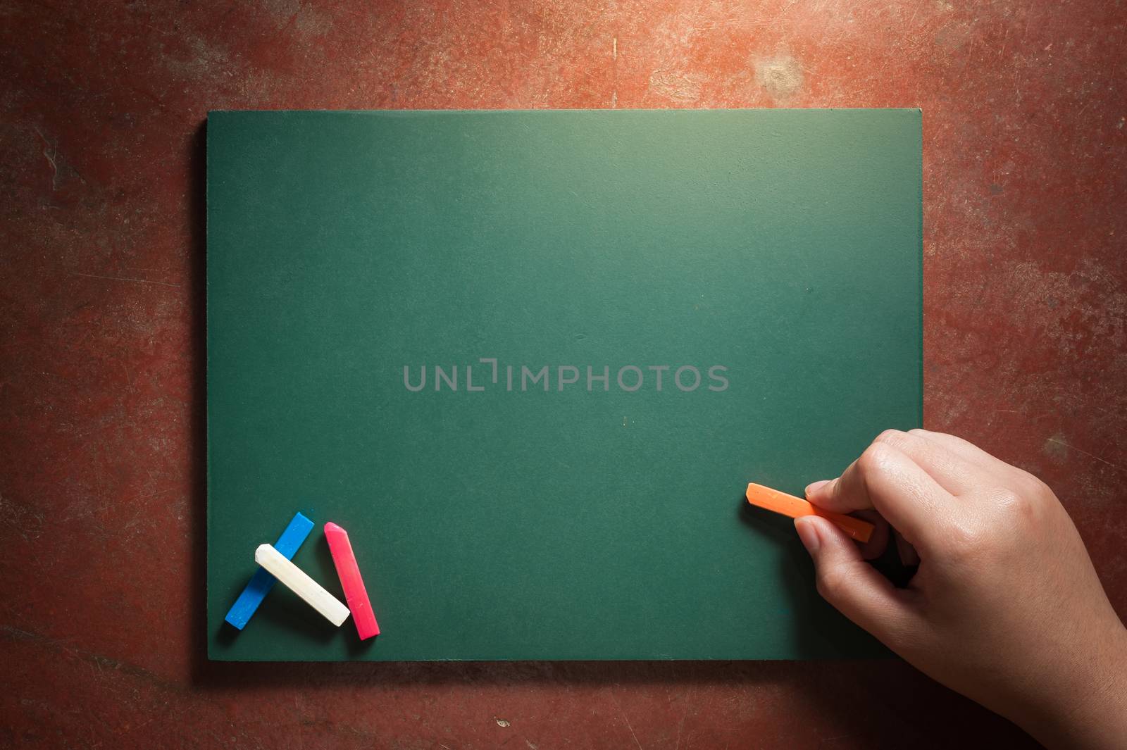 Woman right hand writing on small black board in green color with blank space for text or message with low key scene