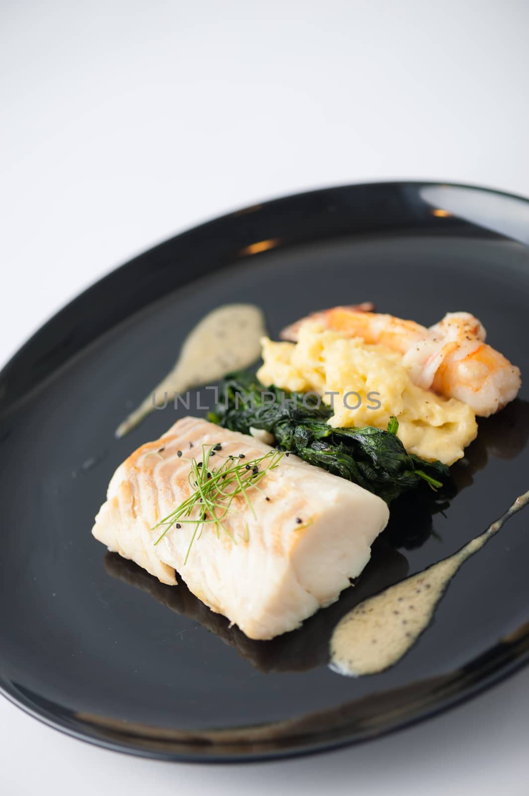 Cod fish steak with shrimp, mesh potato, and vegetable, modern style food