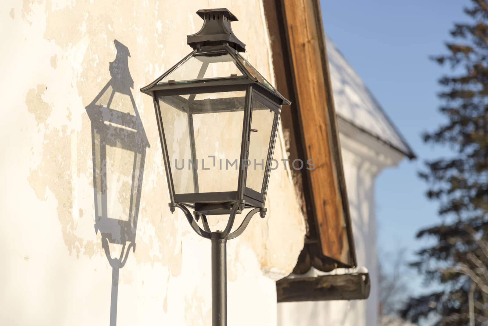 Old Street Light with its shadow on a wall.