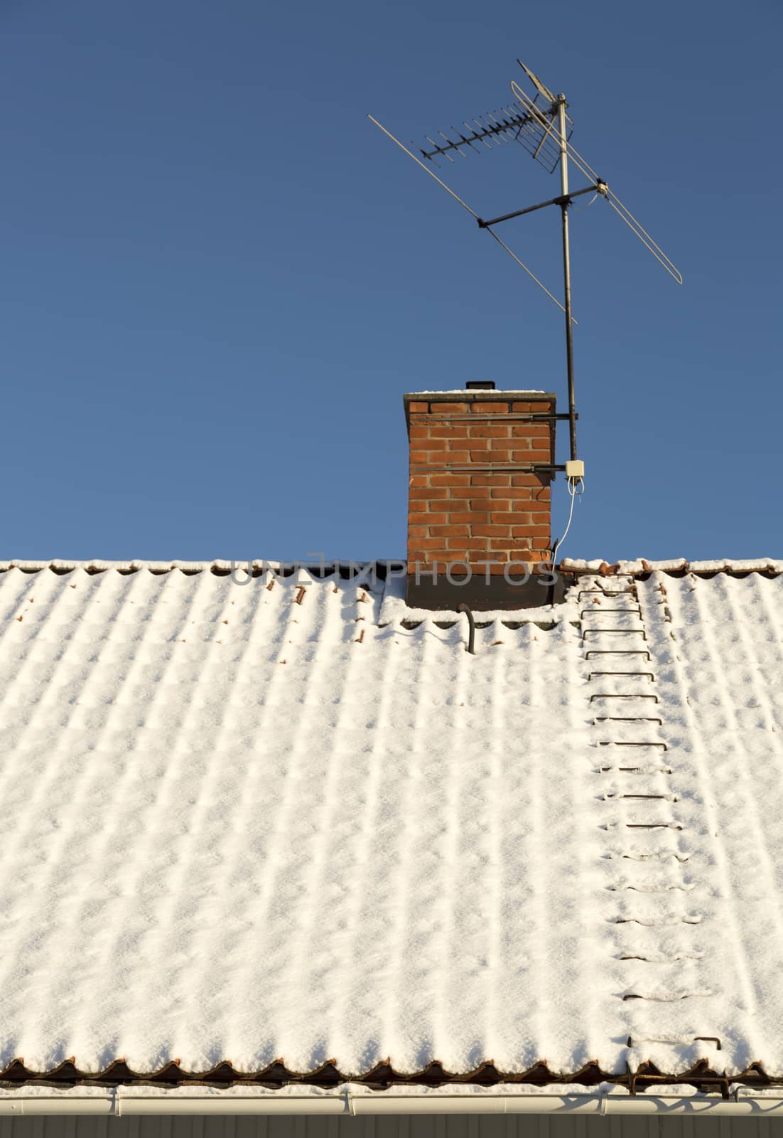 Snow Covered Roof with Chimney and TV Antenna.