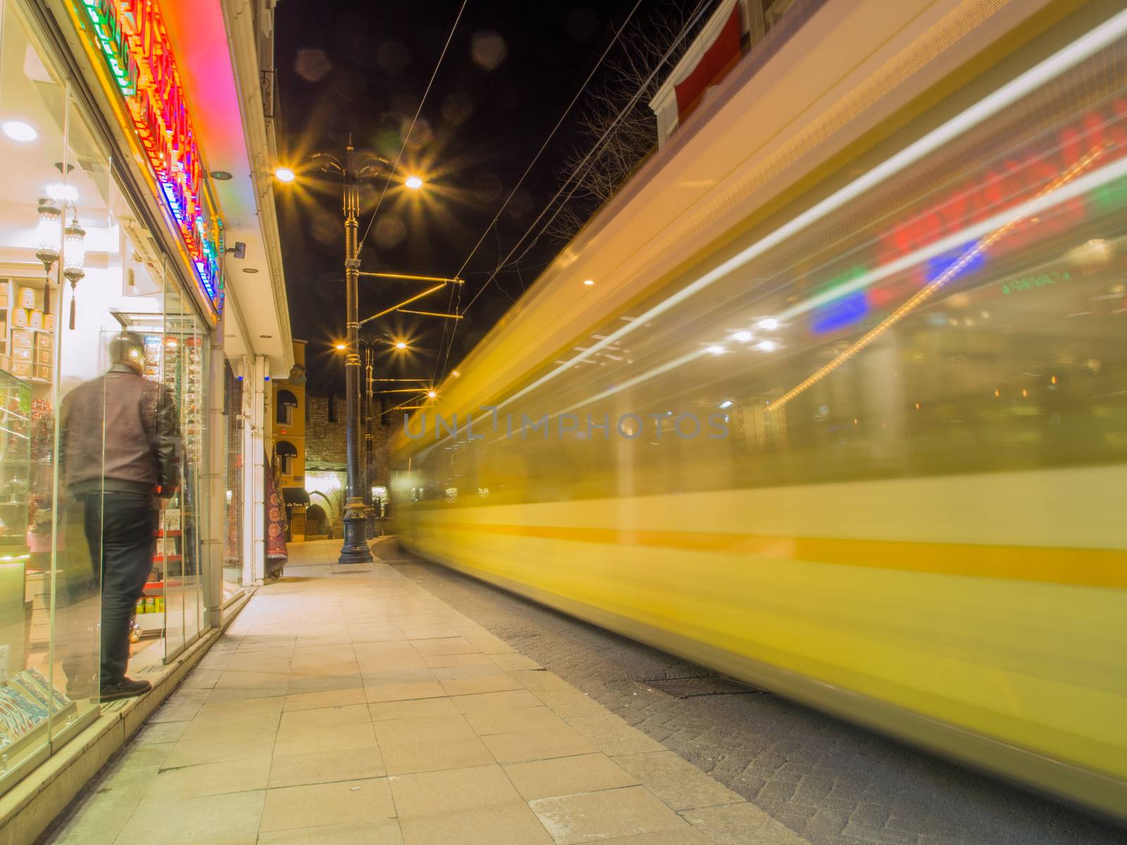 Commuter passenger tram moving down street with motion blur effect.