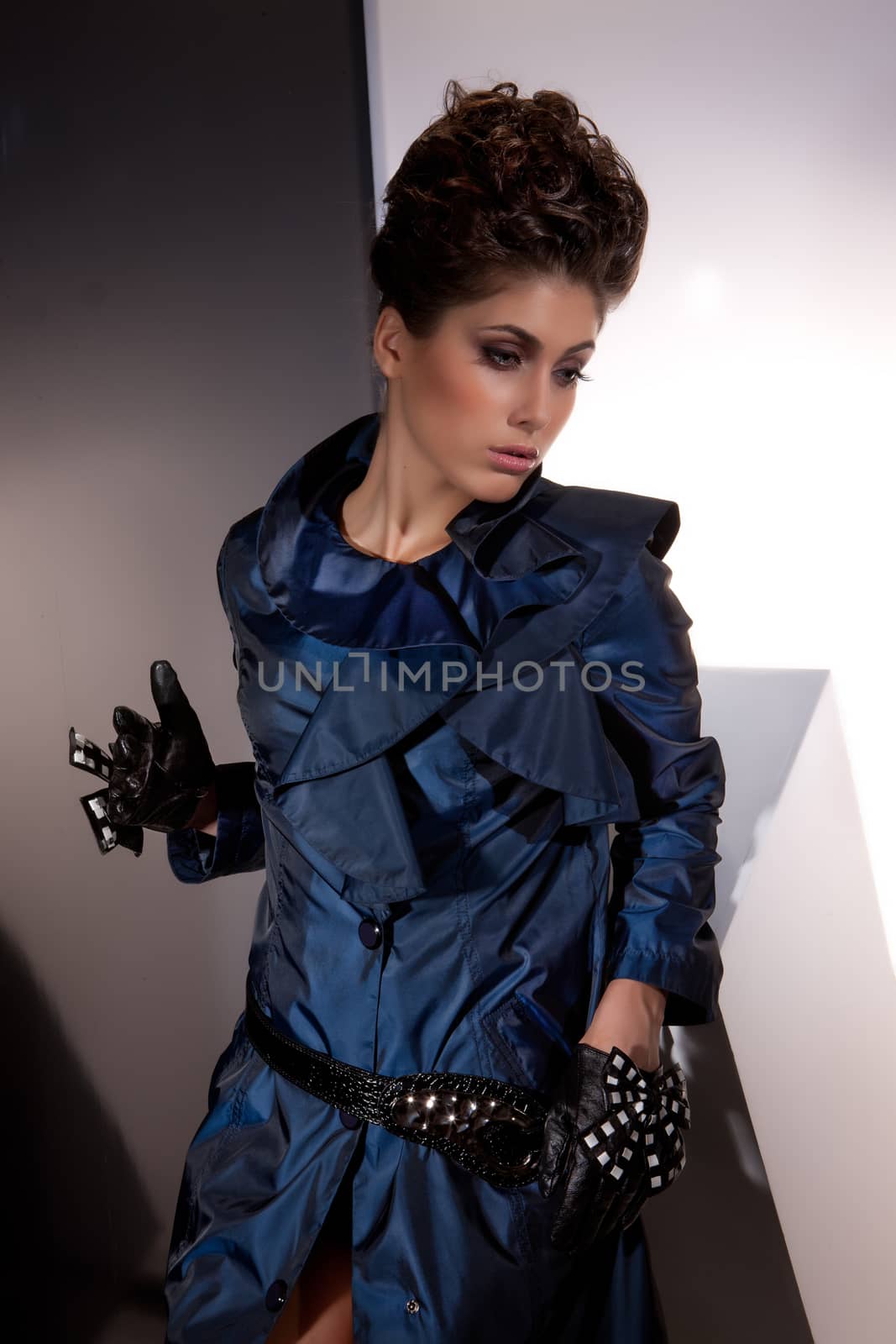 Young beautiful woman in fashionable clothing on isolated studio background