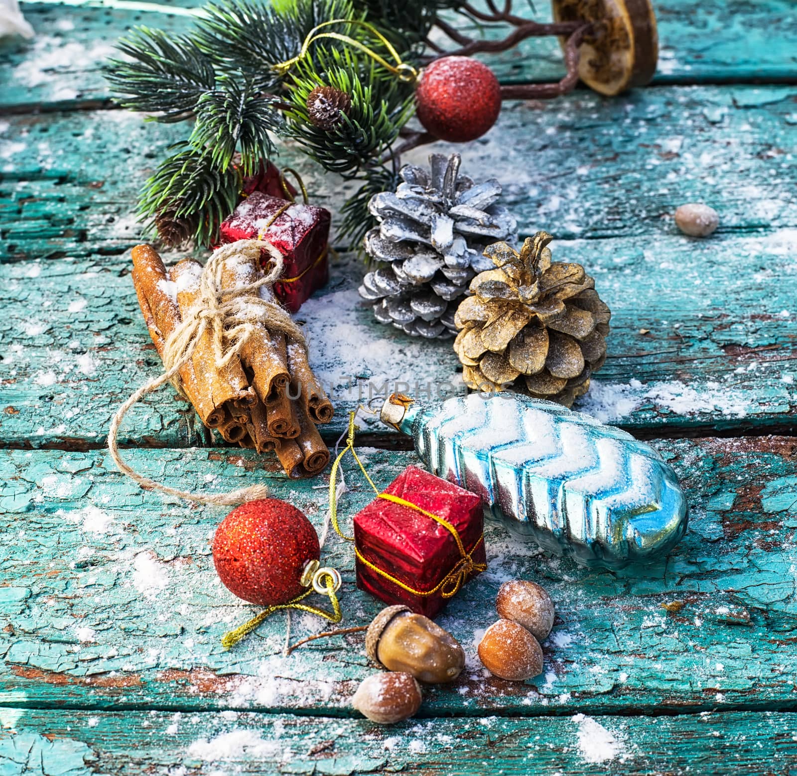 Gifts and decorations for Christmas on wooden background strewn with pine cones and spices
