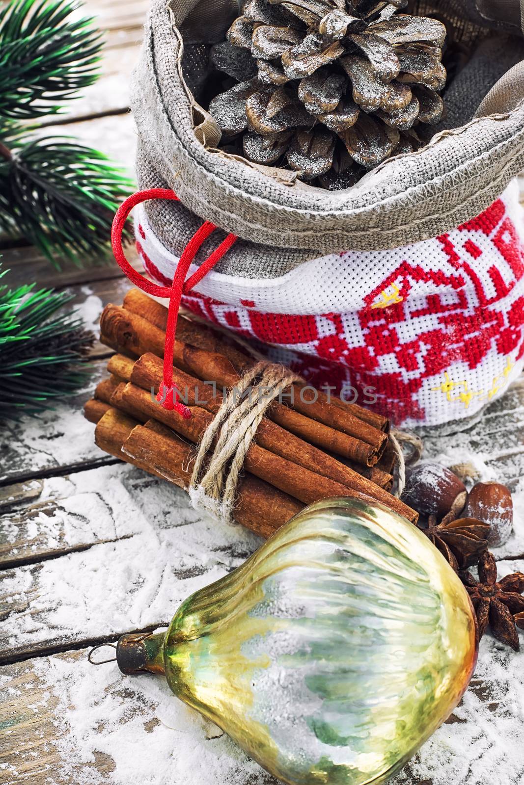 Christmas bag with pine cones on wooden snowy background