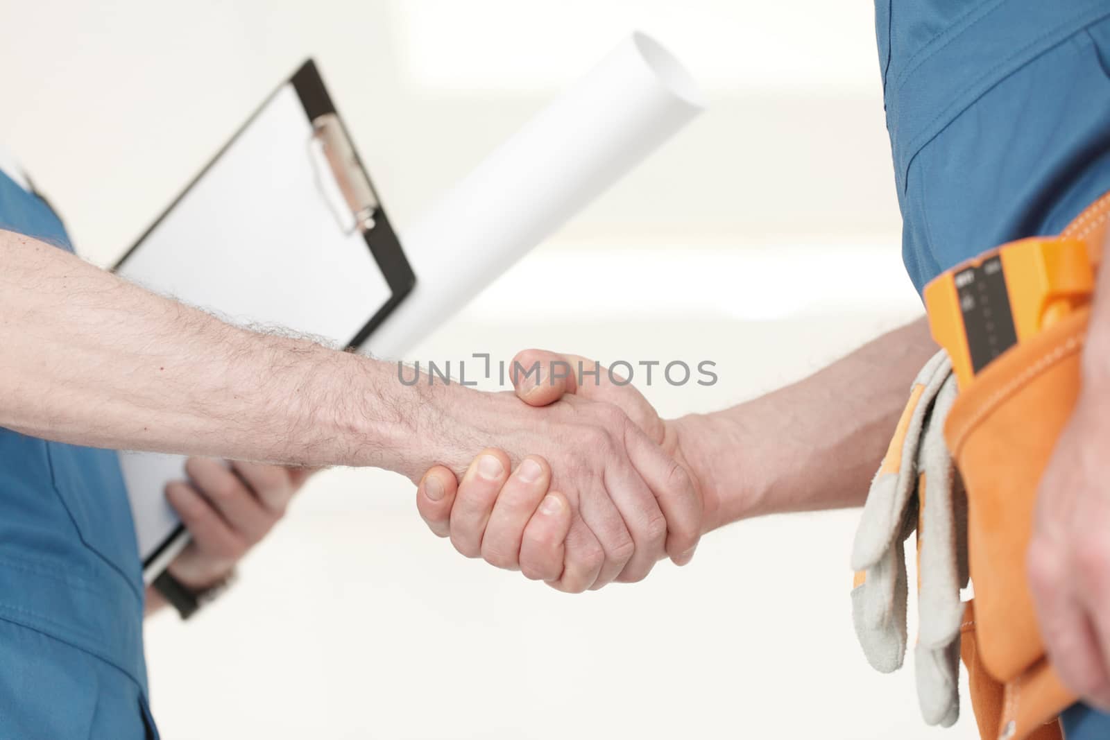 Construction workers shaking hand by ALotOfPeople