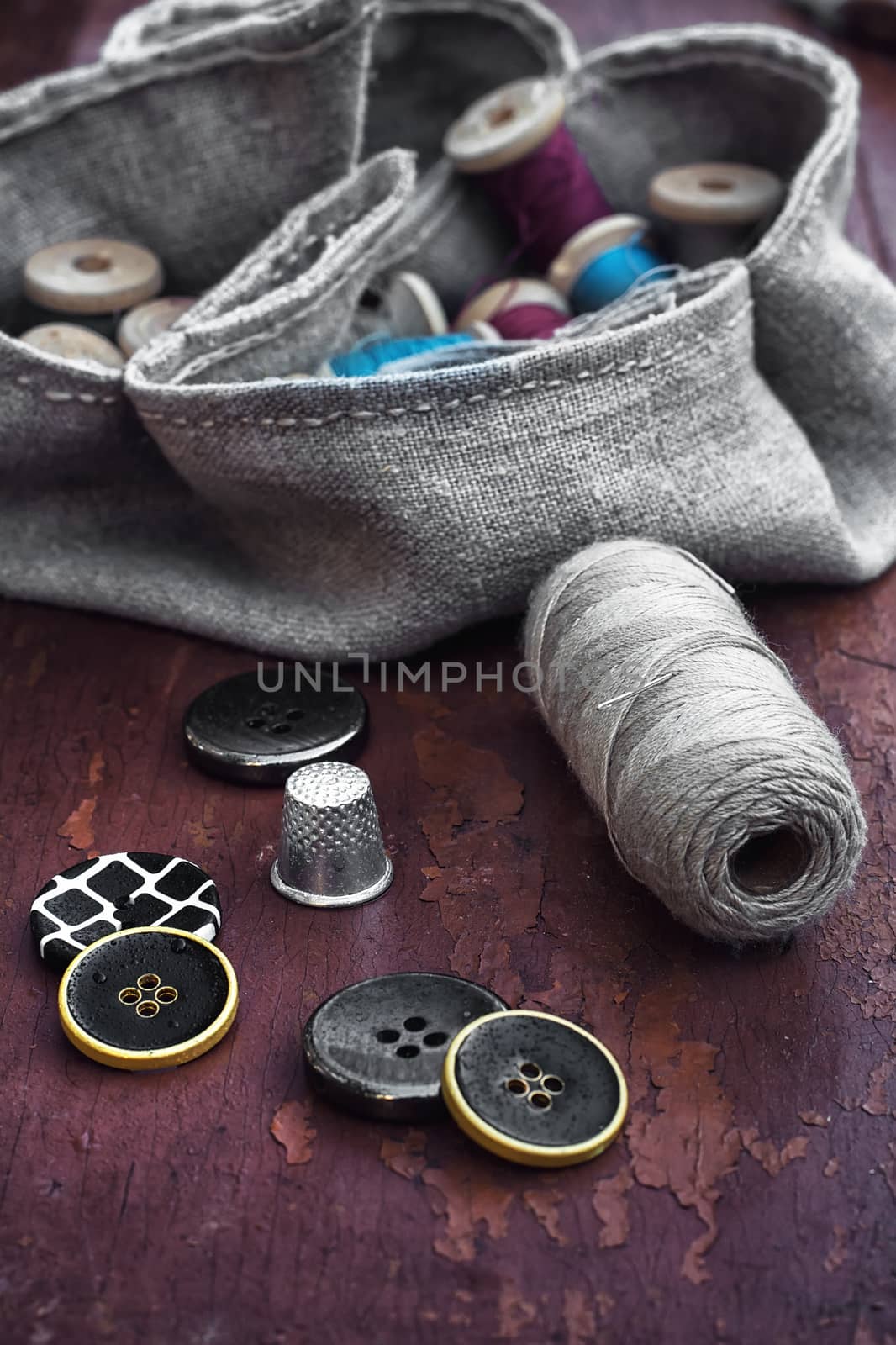 set of threads and buttons on old wooden background