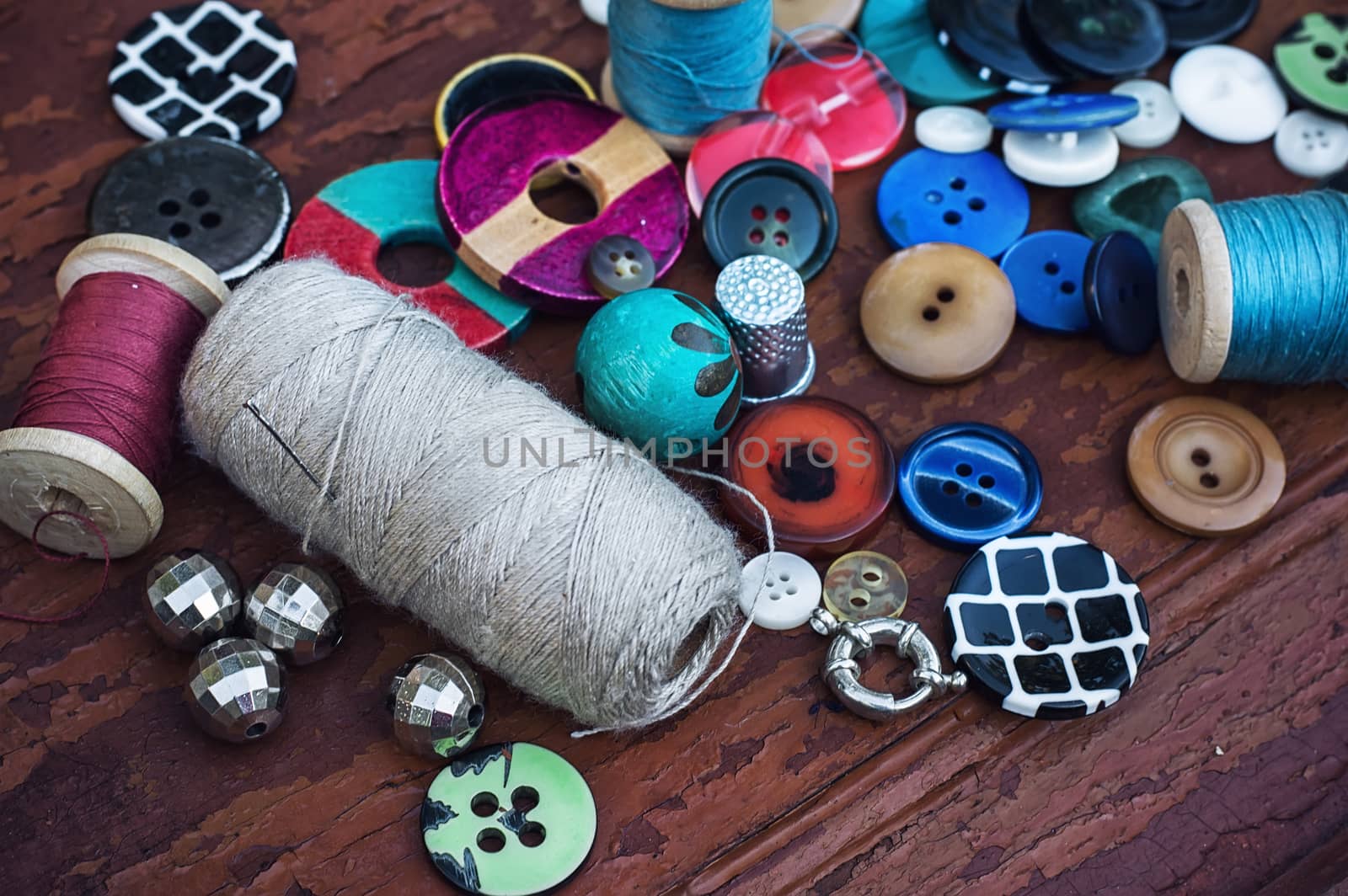 set of threads and buttons on old wooden background