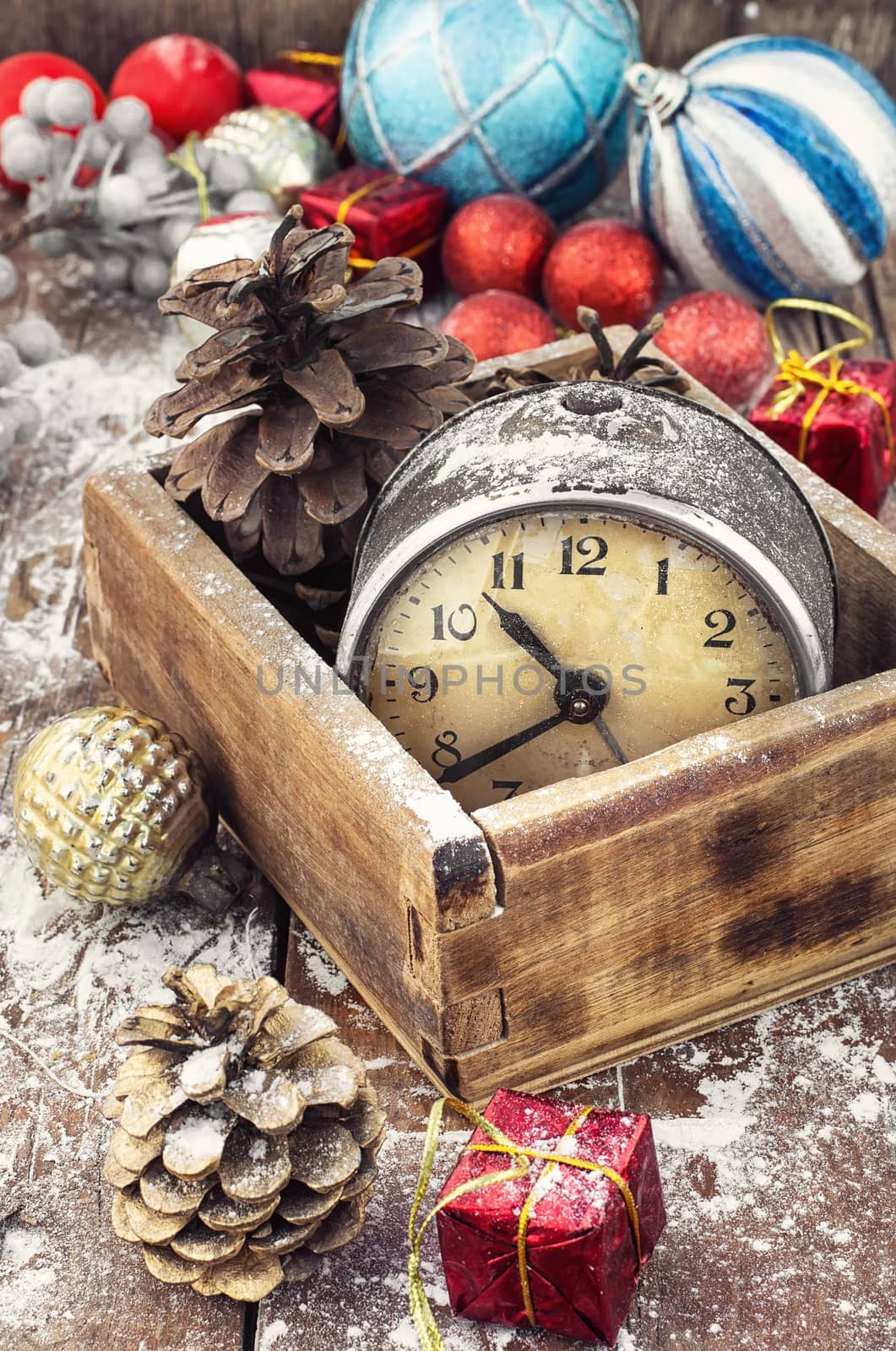 outdated watch in wooden box on the background of Christmas decorations and pine cones.Photo tinted.
