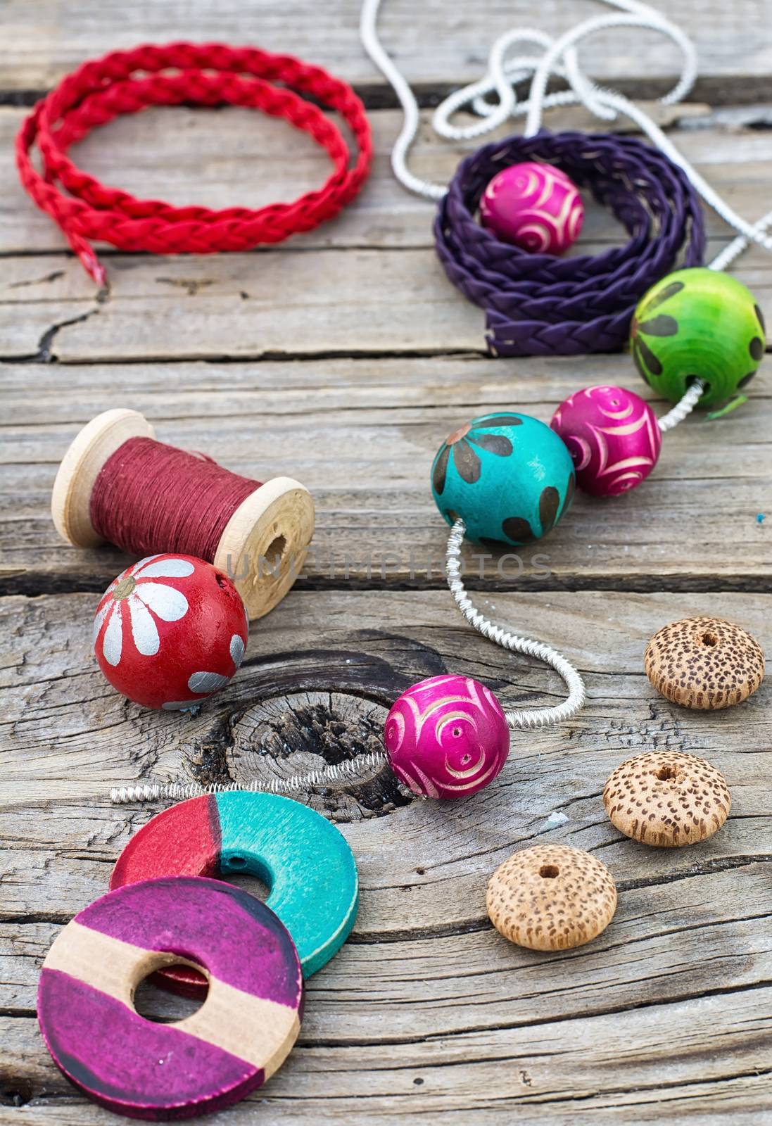 accessories of beads and threads for needlework on wooden plank